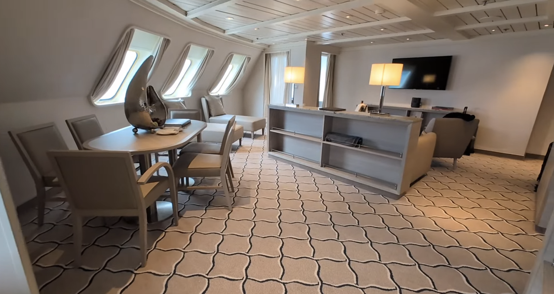 Silversea suite with dining table, sitting area and ocean-view windows