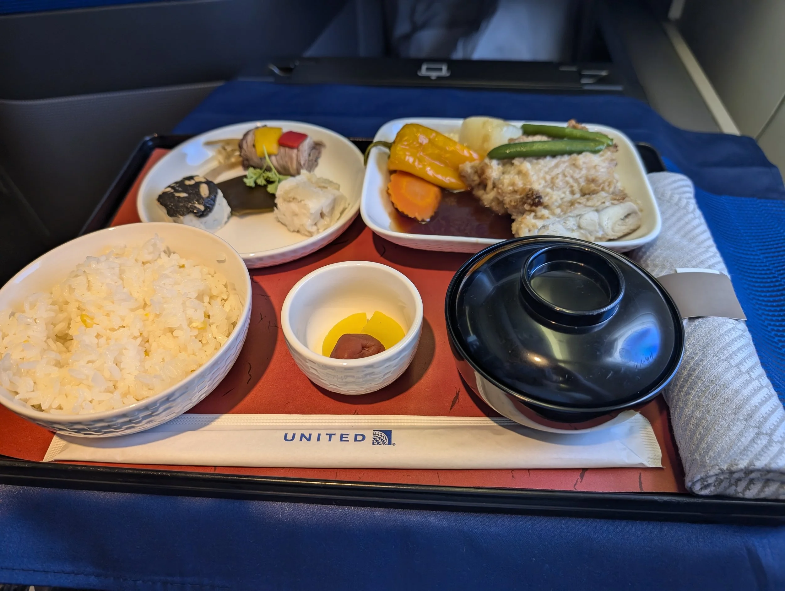 Japanese meal tray with rice, miso soup and small plates in United Polaris business class from San Francisco to Osaka