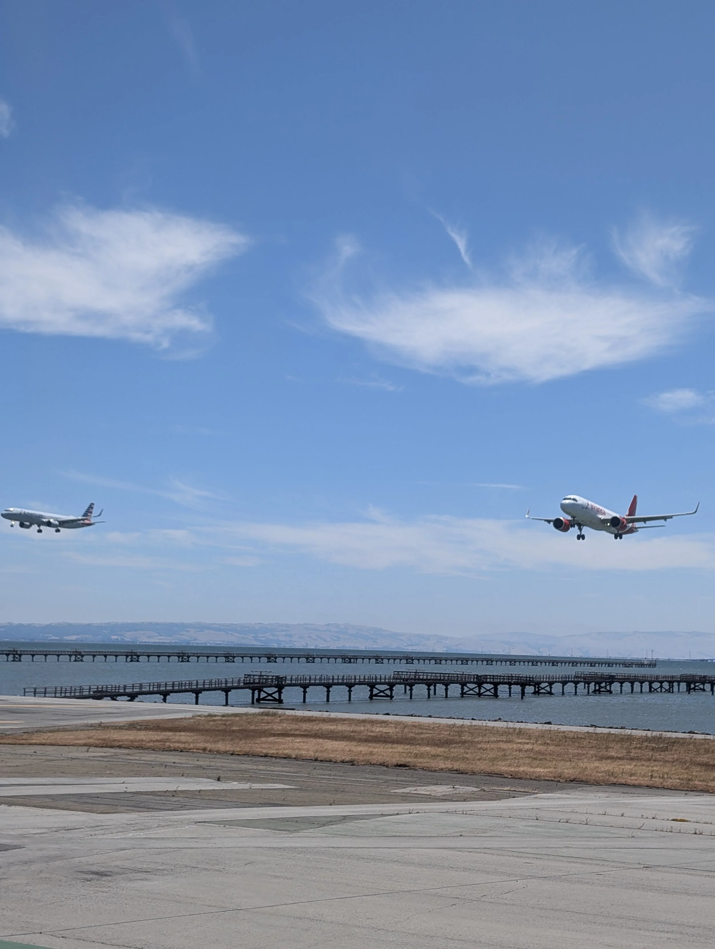 Two passenger jets landing side by side on parallel runways at San Francisco International Airport