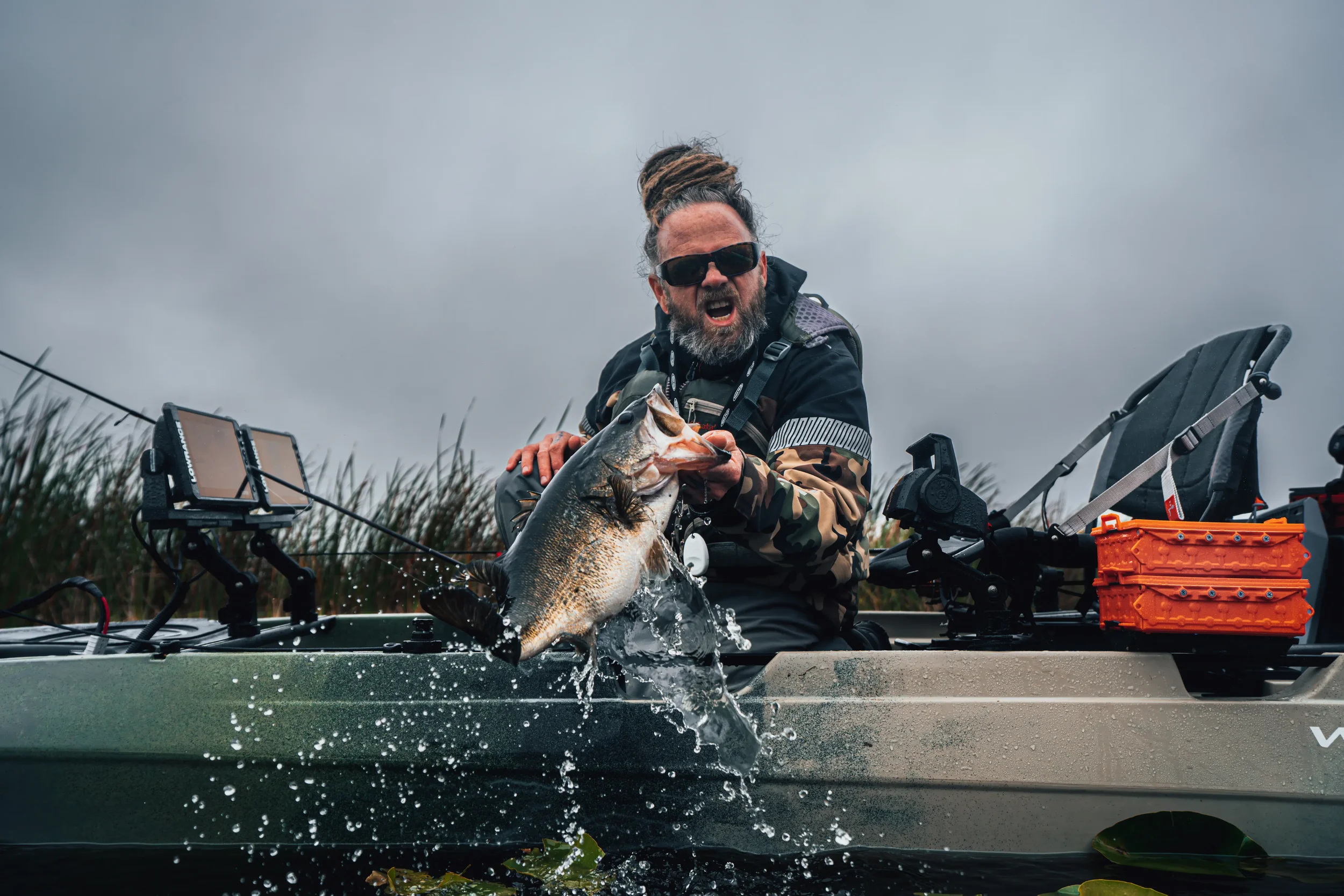 A man holding a large fish off of the Wilderness Systems Tactical Pro 128.