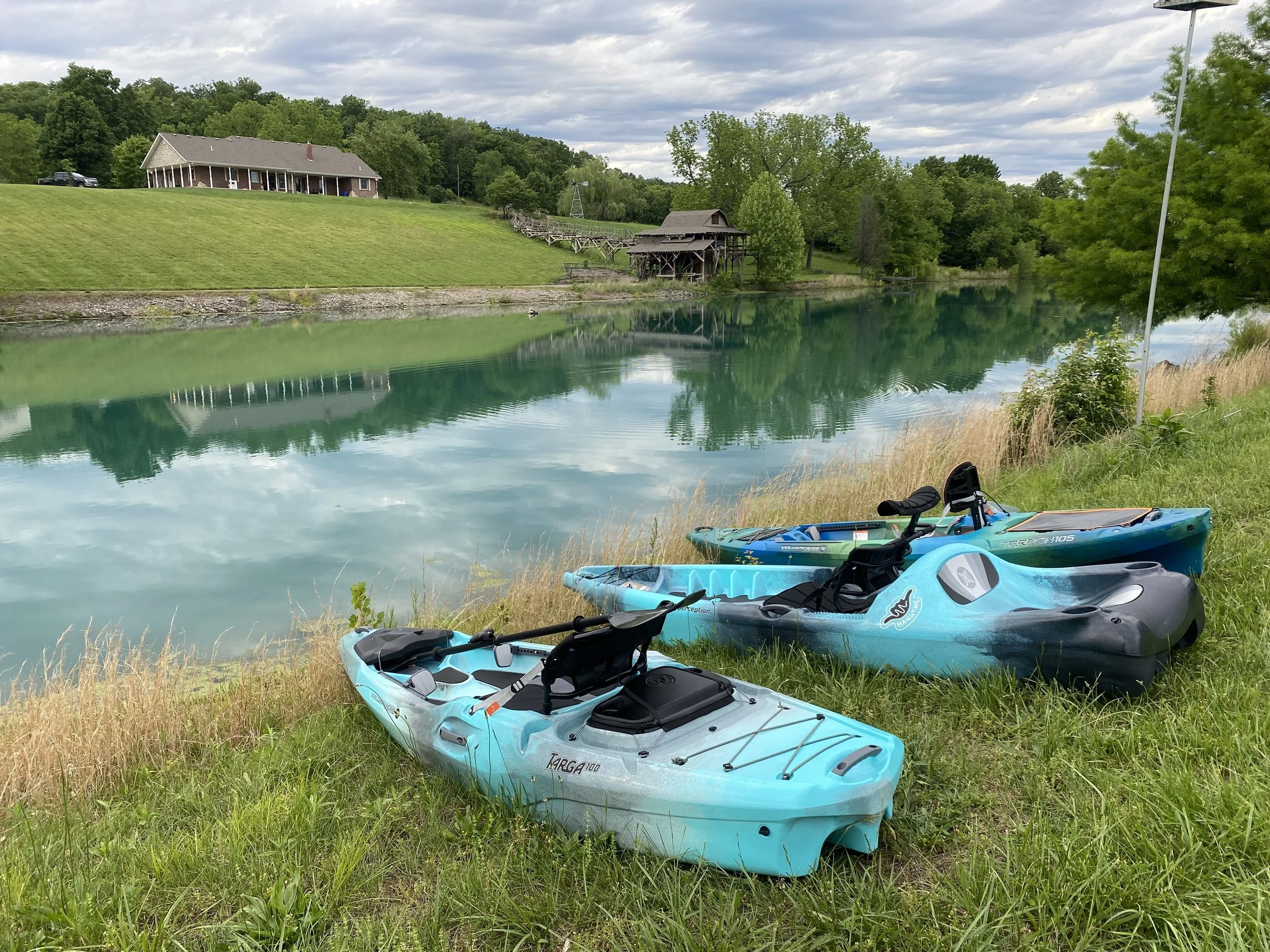 The Wilderness Systems Targa 100, Tarpon 105, and the Perception hangtime 11 lining the beach of Jax Yaks private try before you buy® lake.
