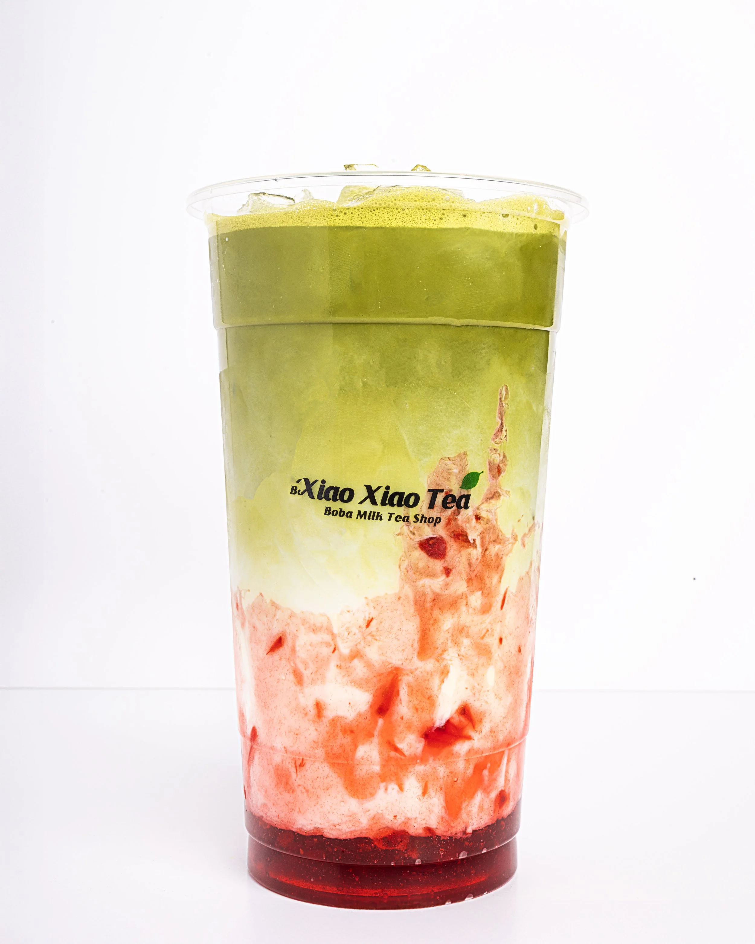 A Strawberry Matcha Latte with the Xiao Xiao Tea logo on the front