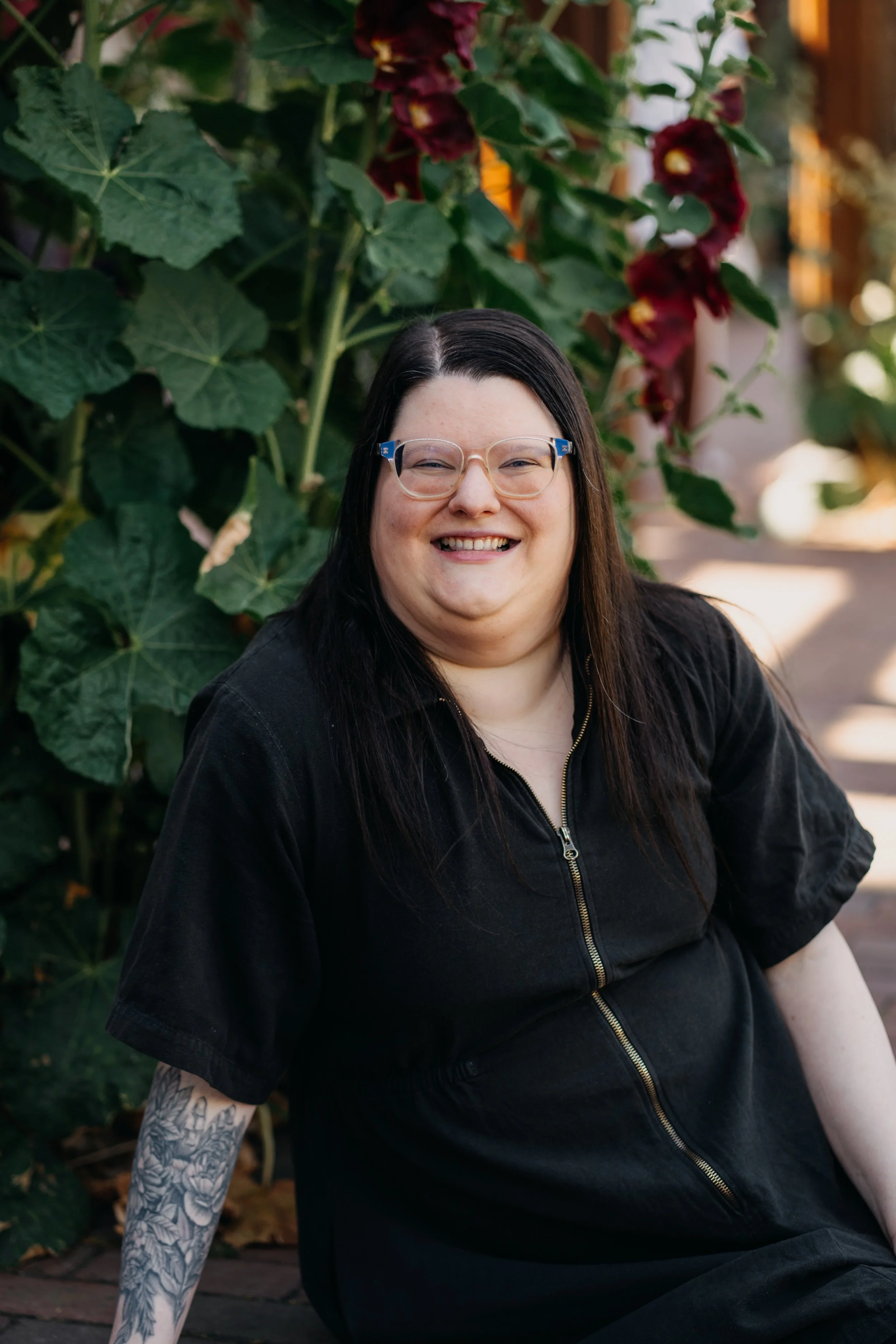Therapist with tattoos against greenery