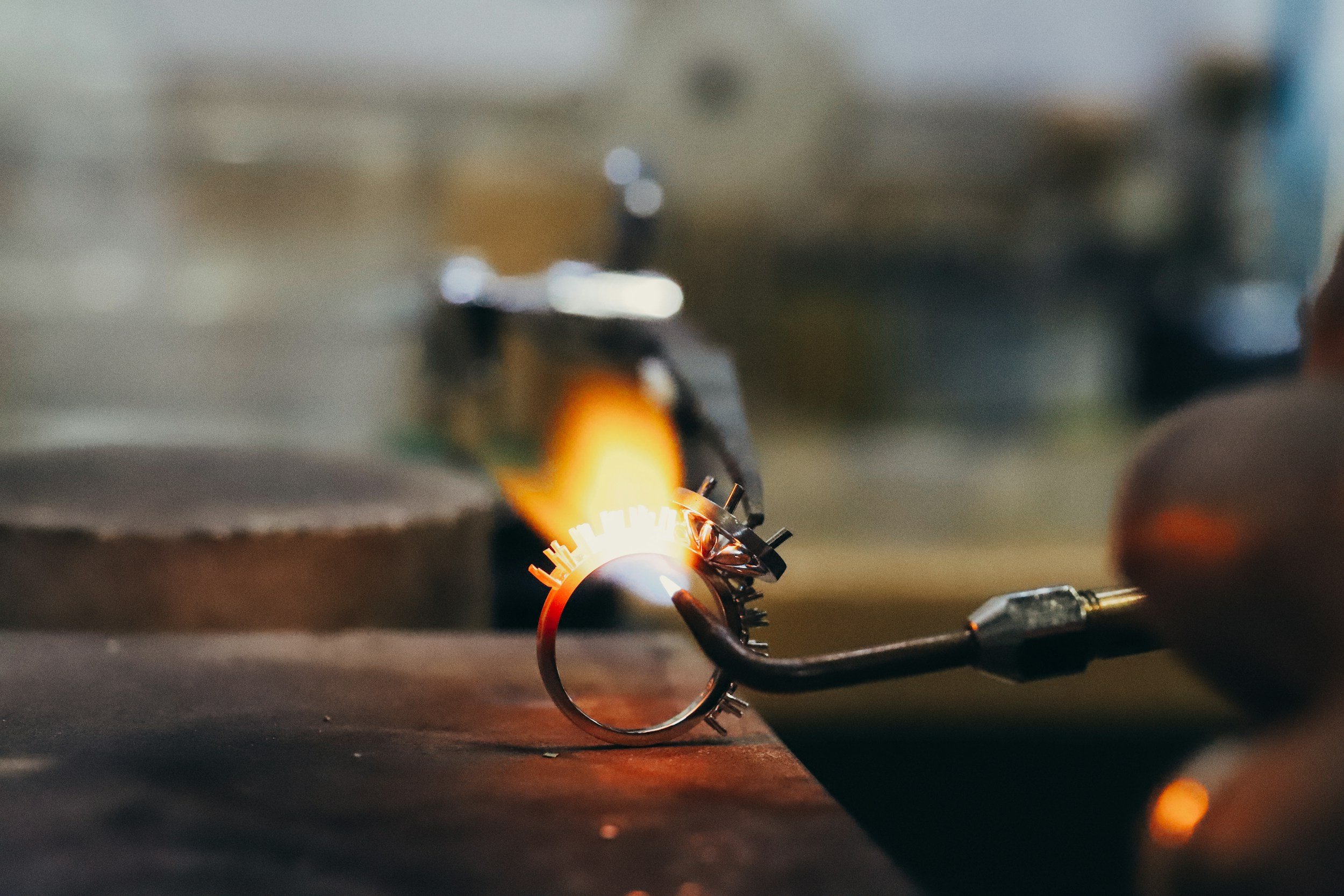 Heating white metal ring with a jewellers torch in adding claws