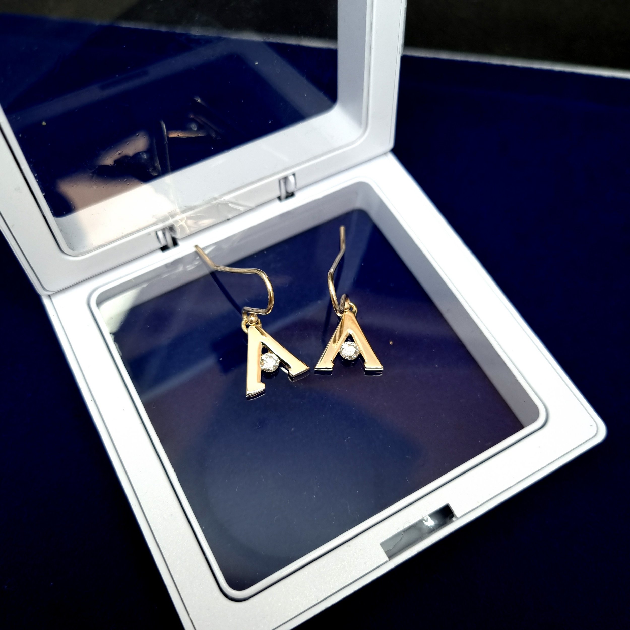 A inital earrings with diamond and yellow gold