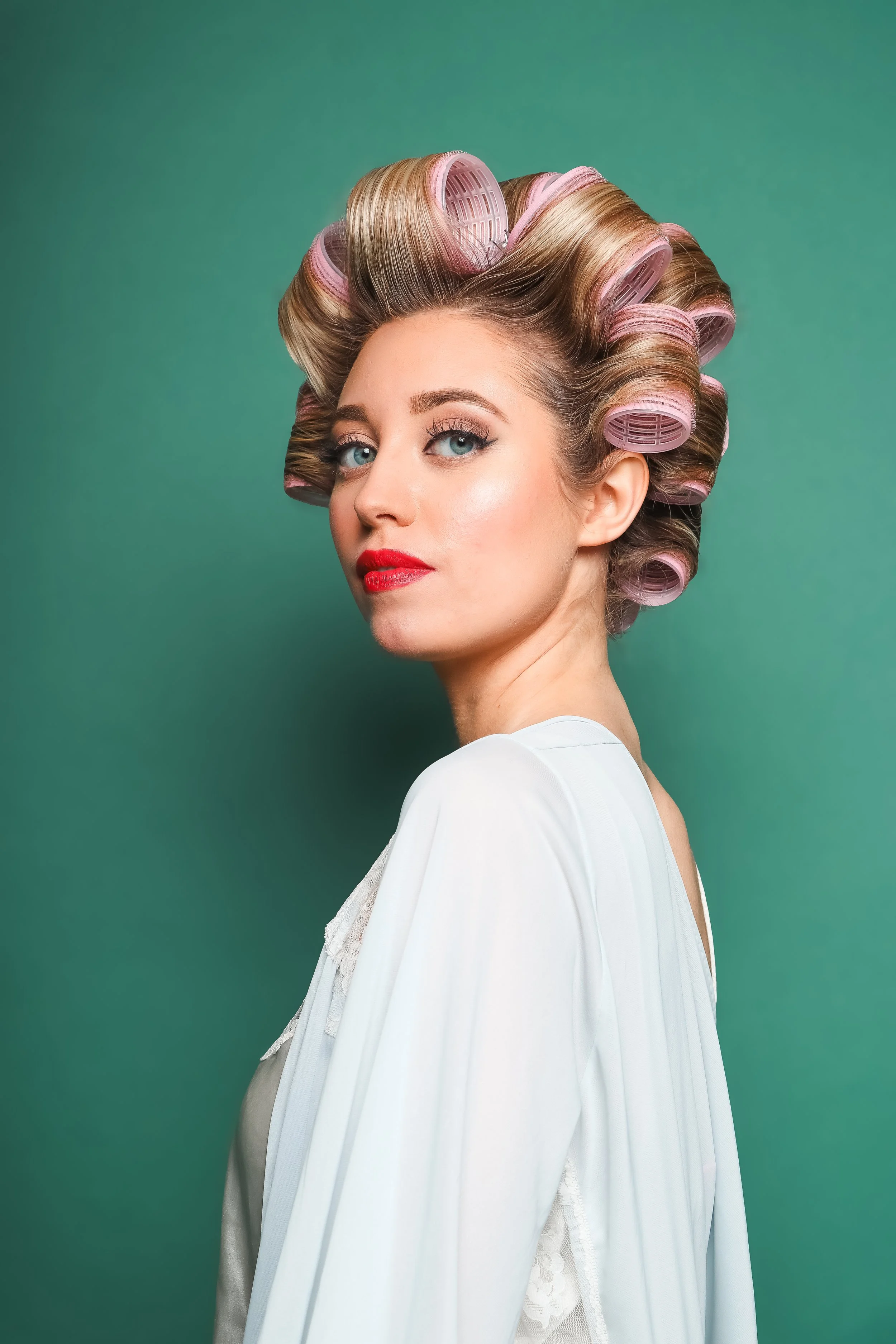 woman with hair curler rollers and vintage phone
