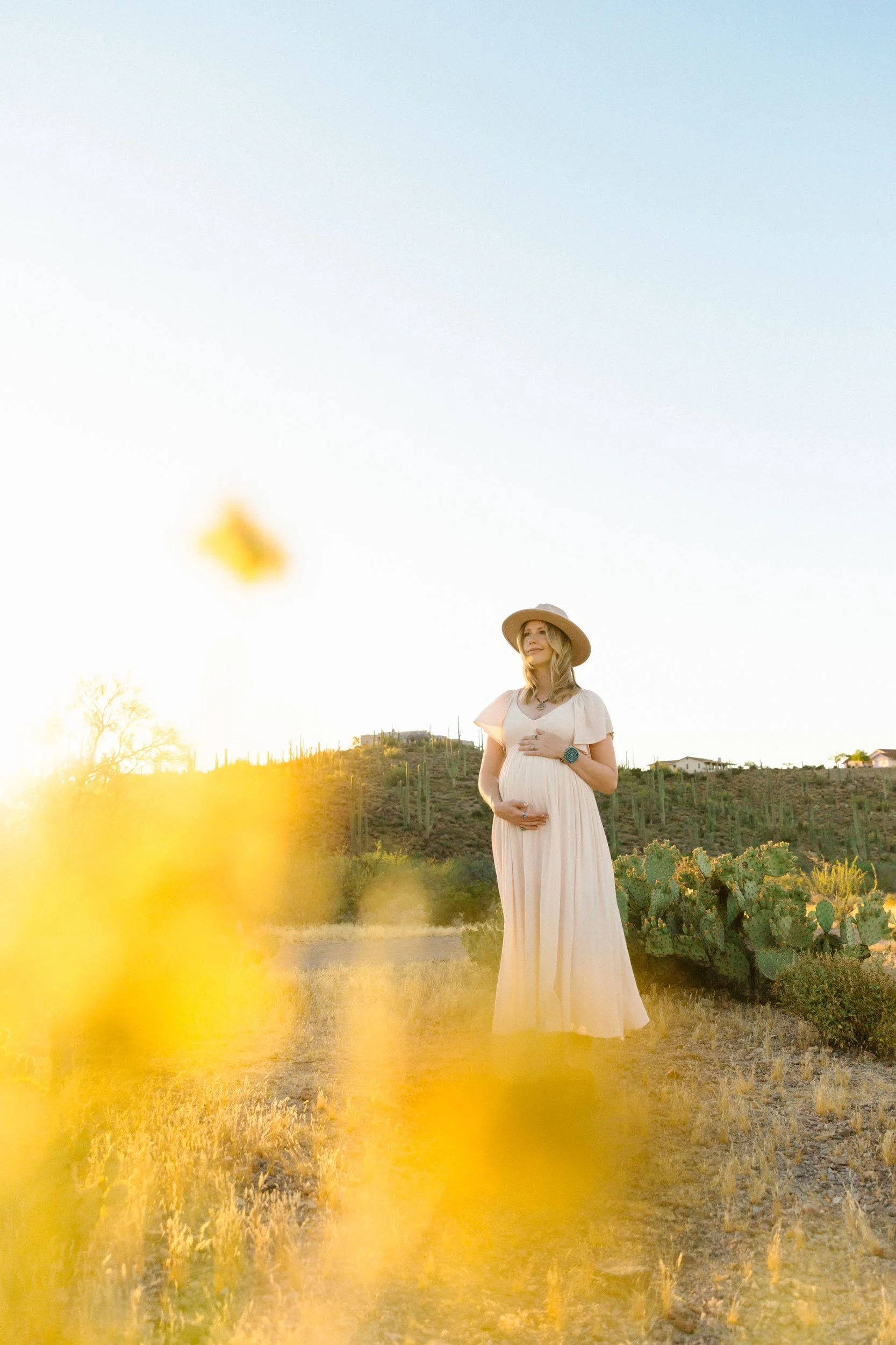 expecting mother enjoys the breeze in the desert at her outdoor maternity session in tucson, az