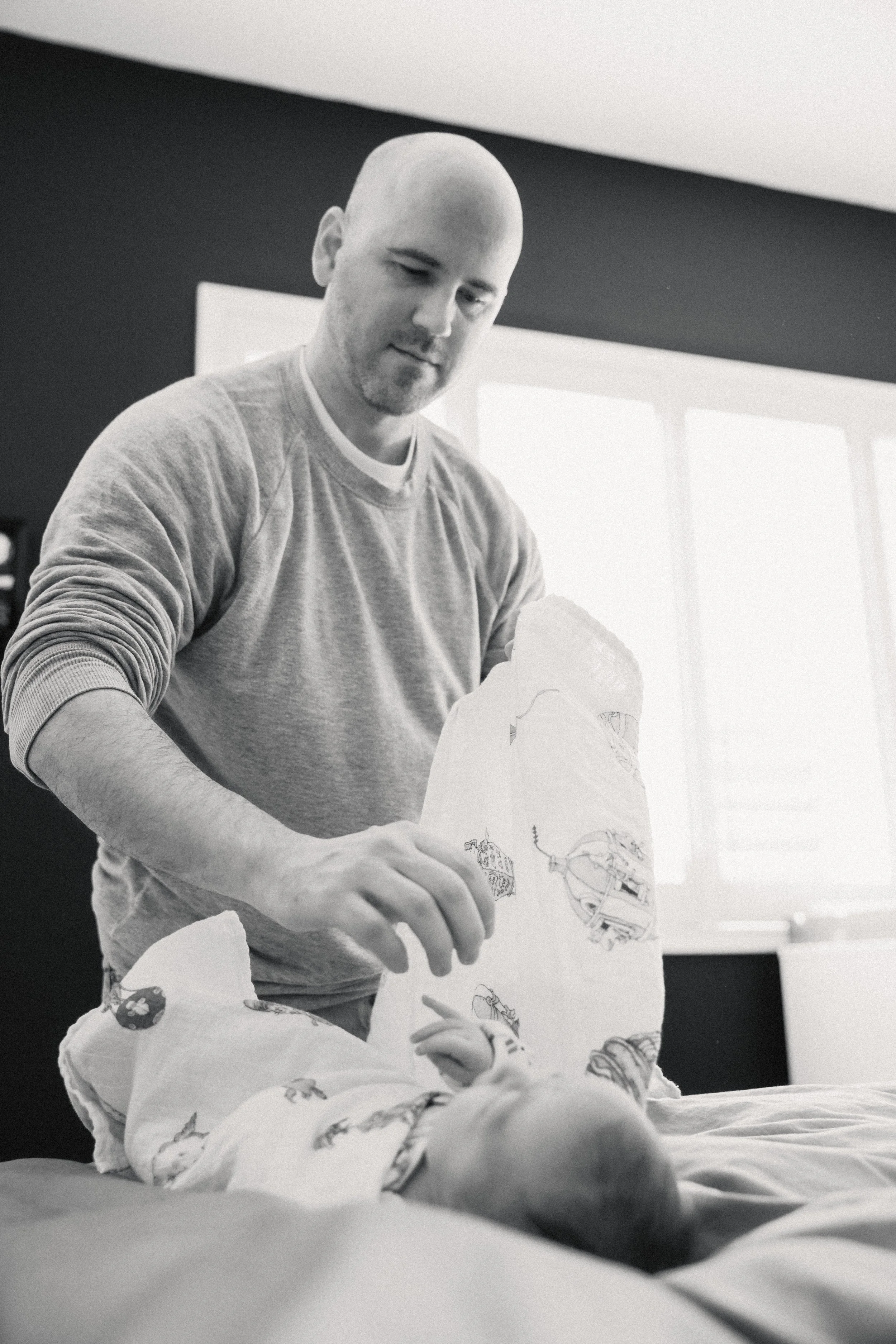 dad swaddling newborn at photo session in tucson, arizona