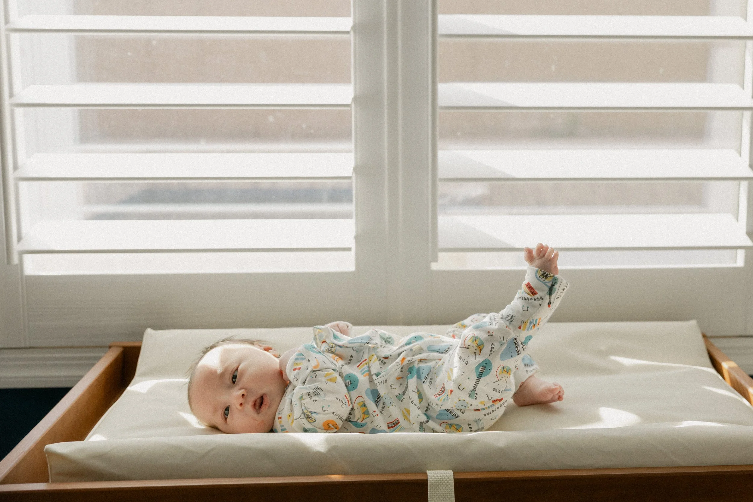 newborn laying on changing table during photo session