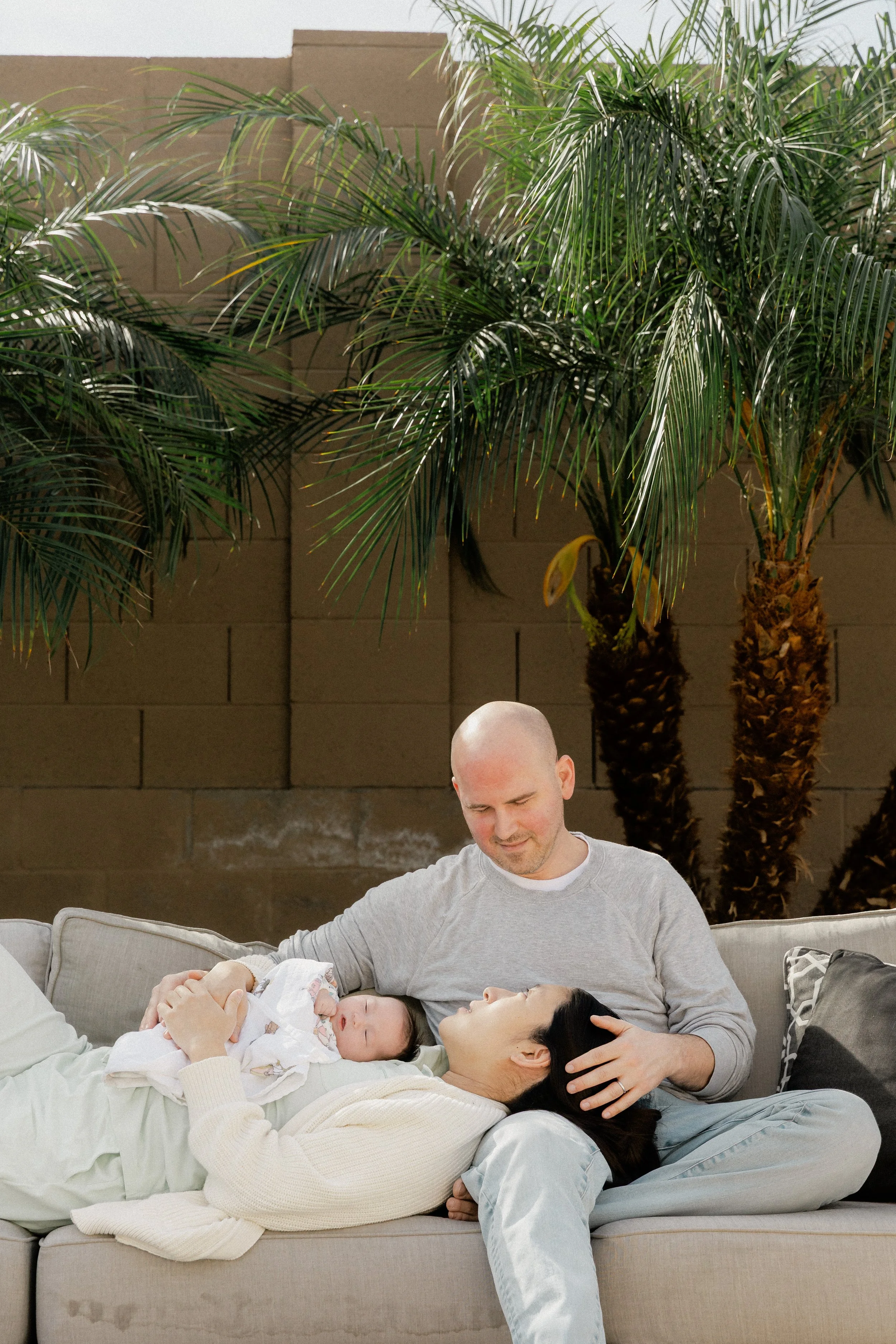 new parents lounge outside with newborn during photo shoot tucson