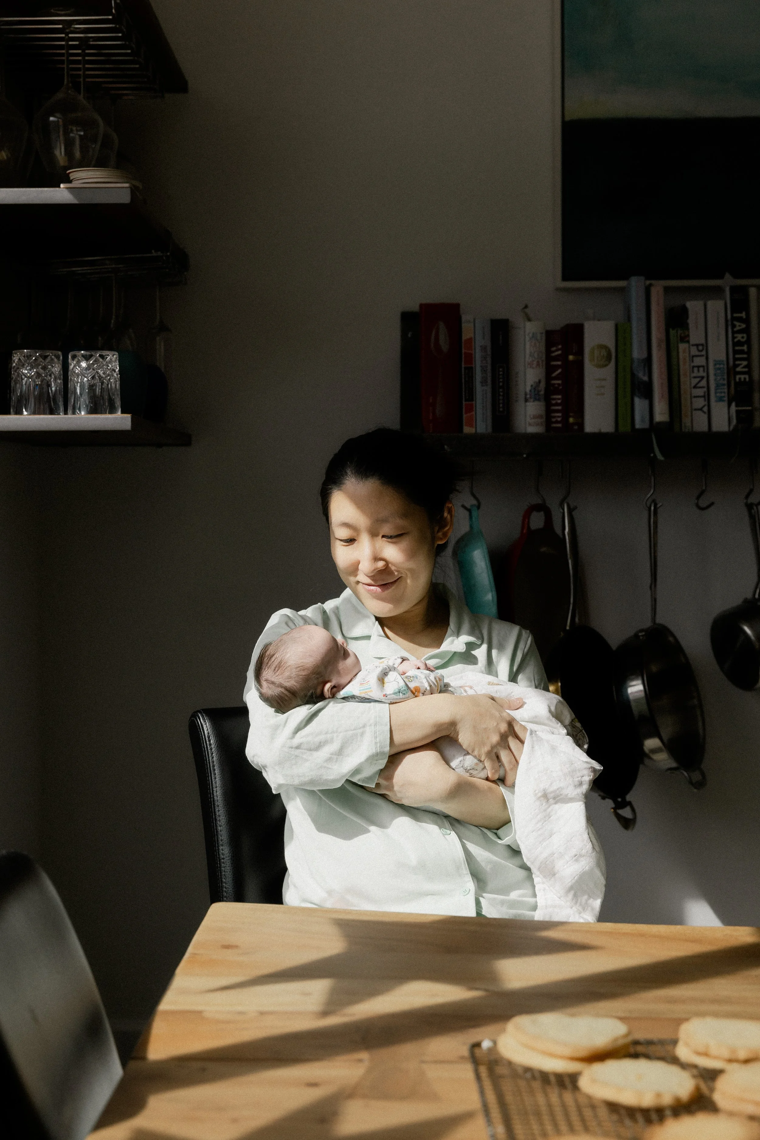 new mom sits with newborn in the light at home in tucson