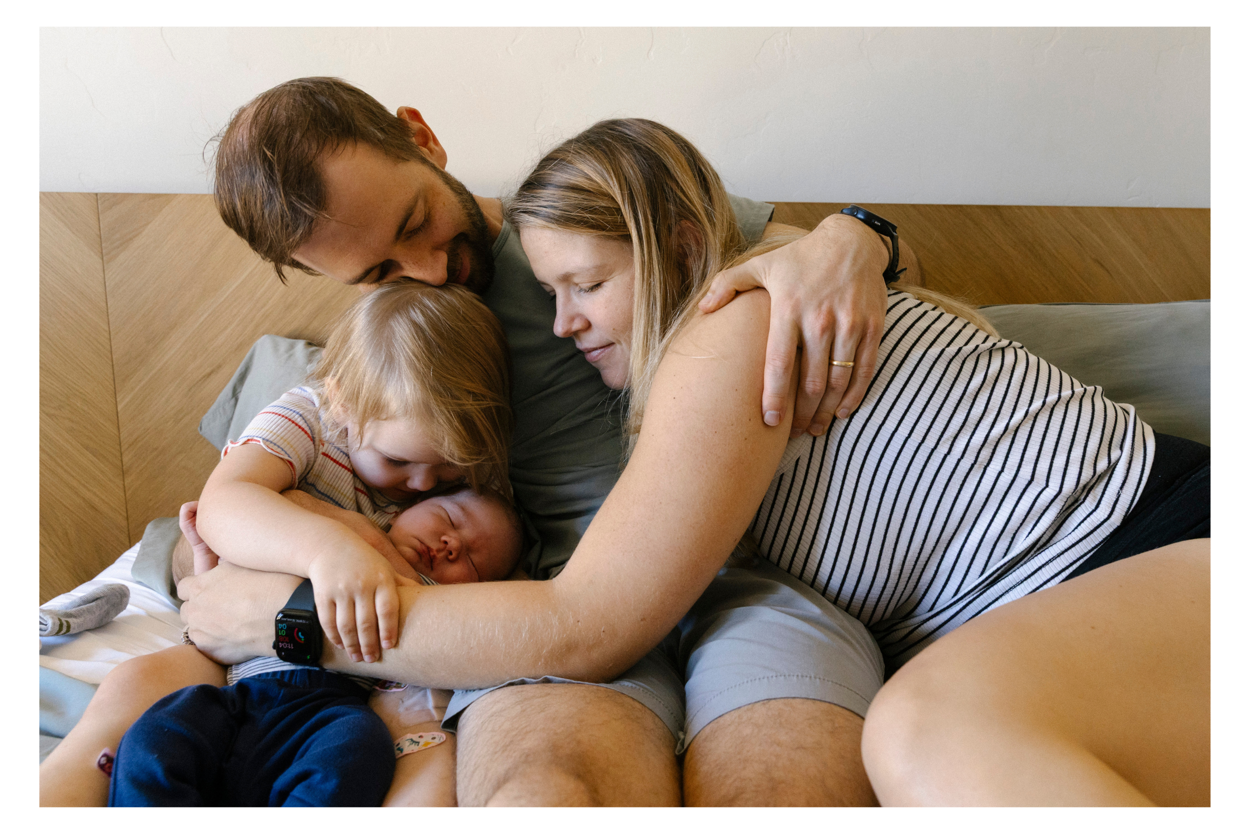 family snuggles their brand new baby at a newborn photo session in tucson