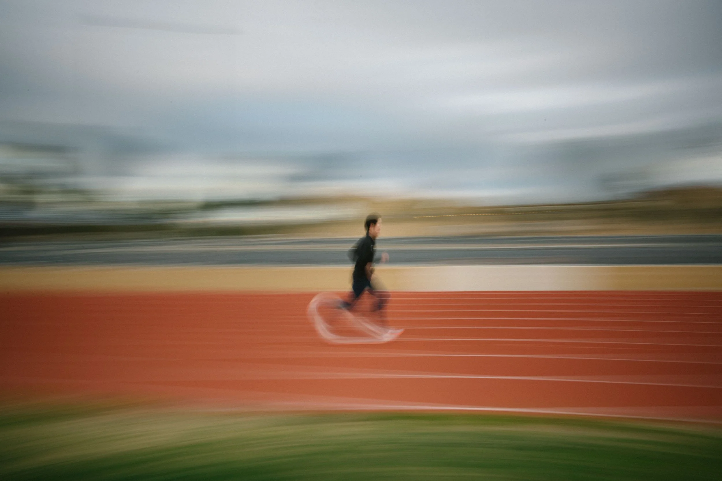 A person running on a track, captured with motion blur, creating a sense of speed.