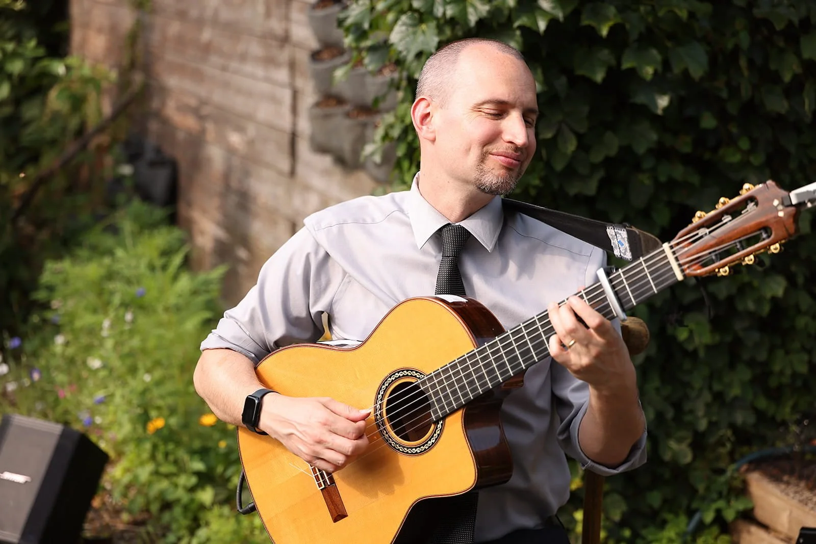 Engineers work with a robotic arm and machinery in a bright, modern industrial lab, while others discuss data near a monitor.