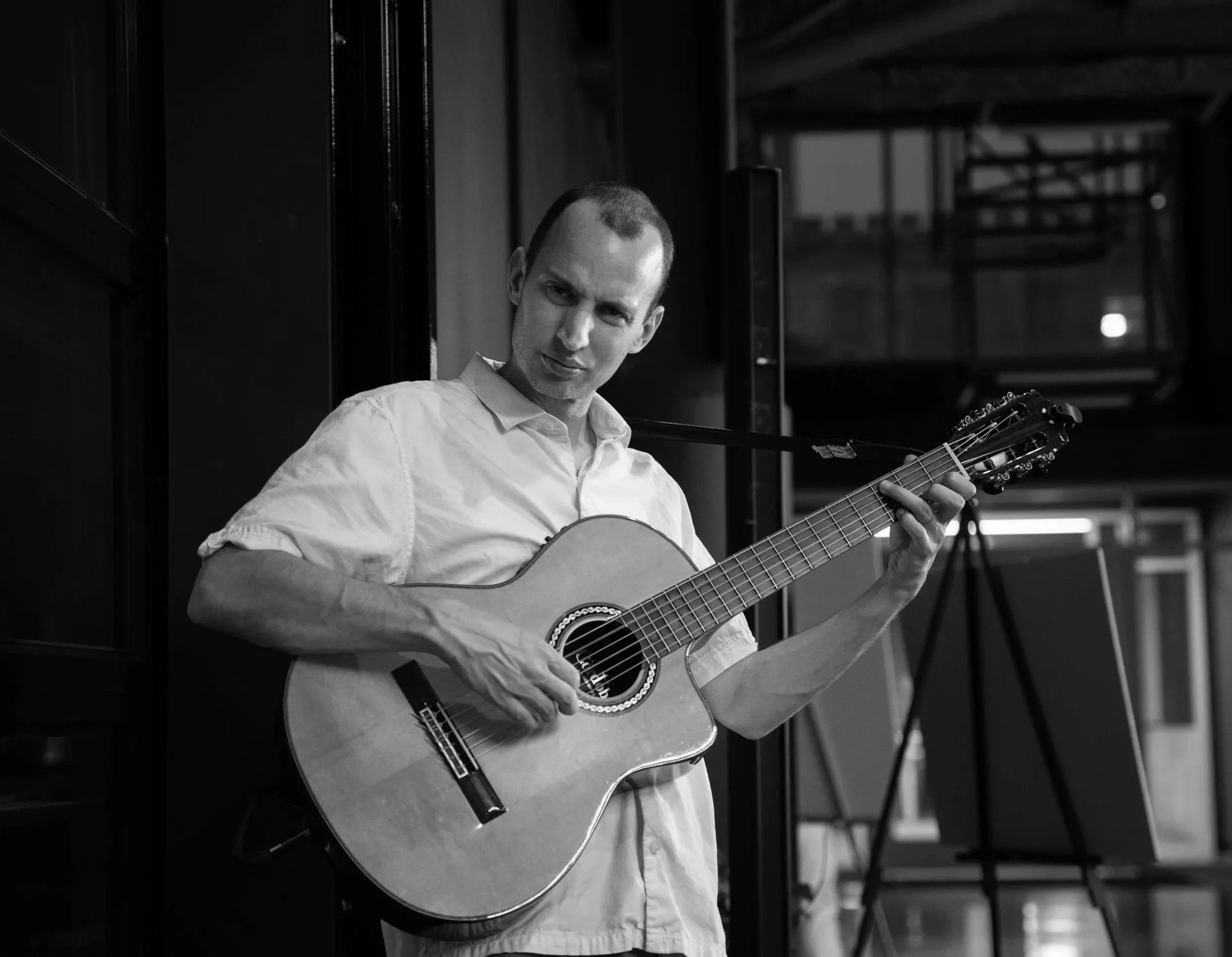 Jim Perona playing classical guitar in a corporate venue setting