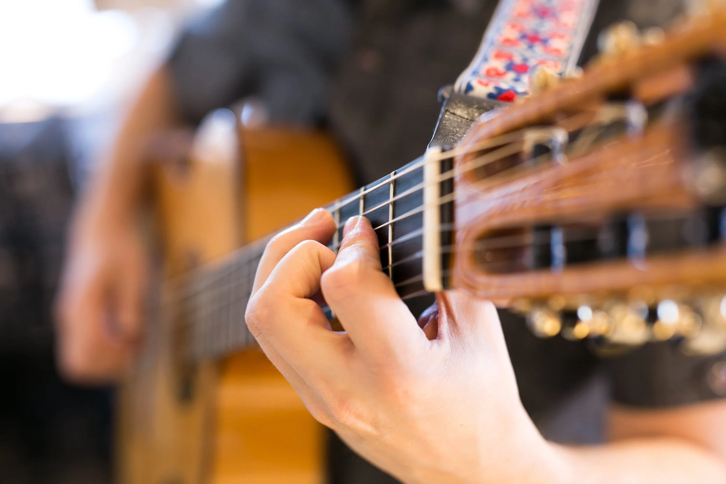 Jim Perona playing guitar in an elegant event space