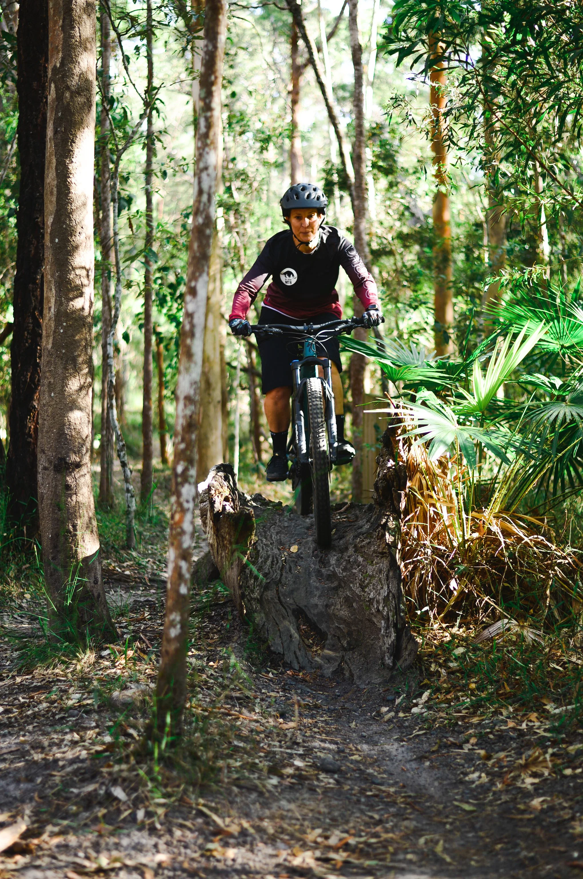 Woman riding a mountain bike wooden feature