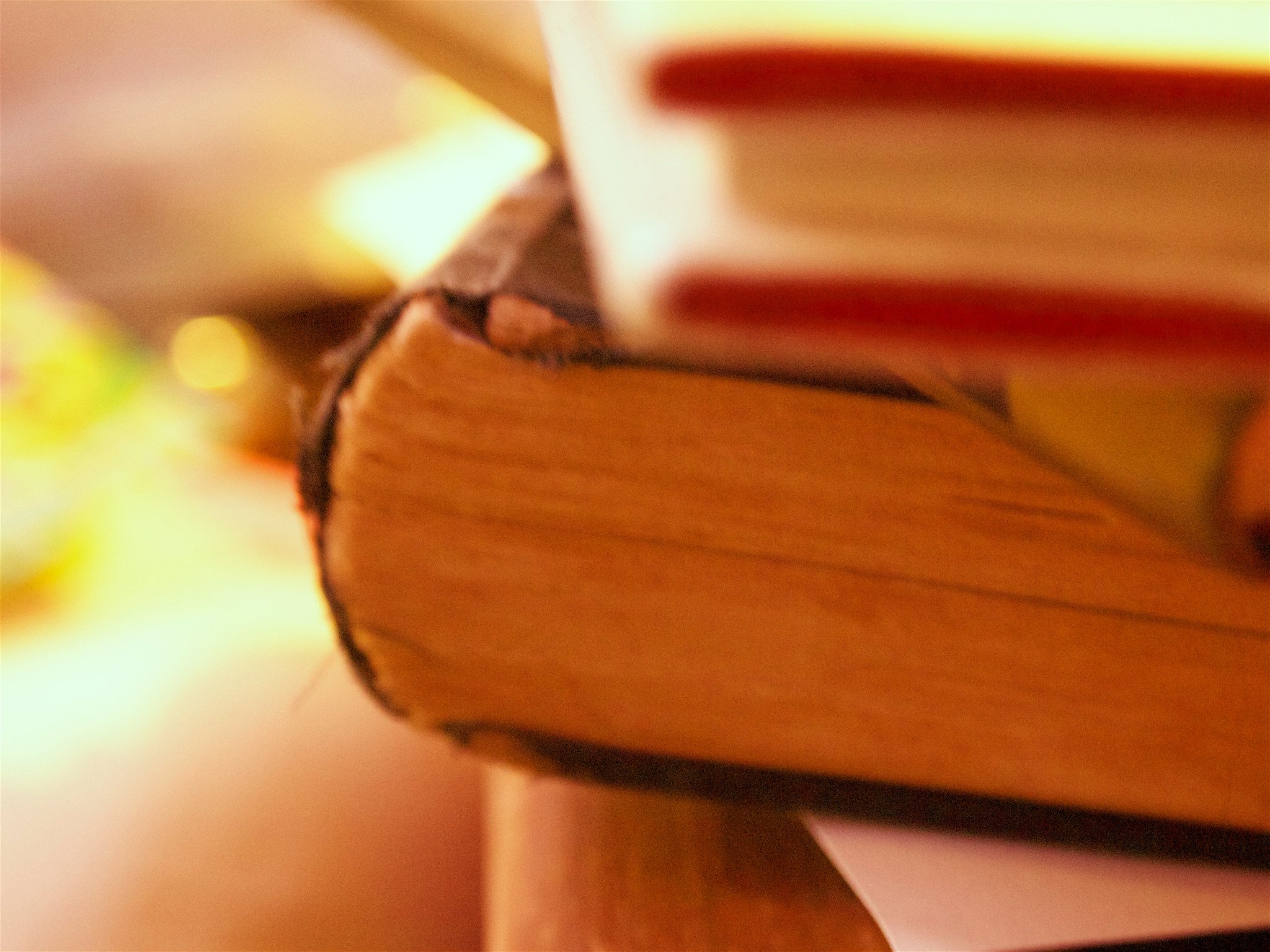 Close-up of the edges of a stack of books with colorful covers, viewed from the side.