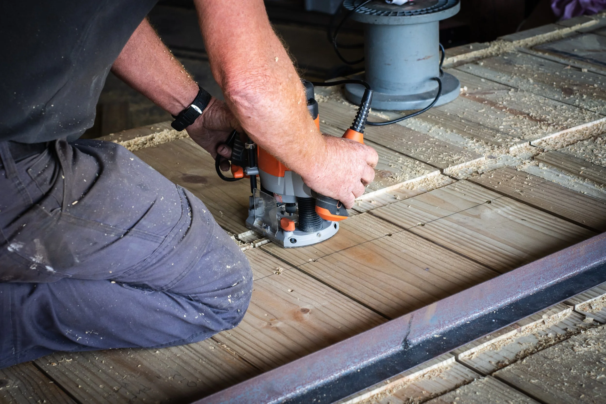 Person using a wood router on a wooden board