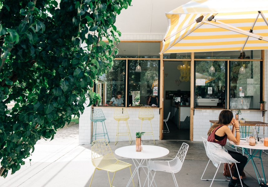 Outside a cafe in Hampton, Melbourne with yellow striped awnings on a sunny day