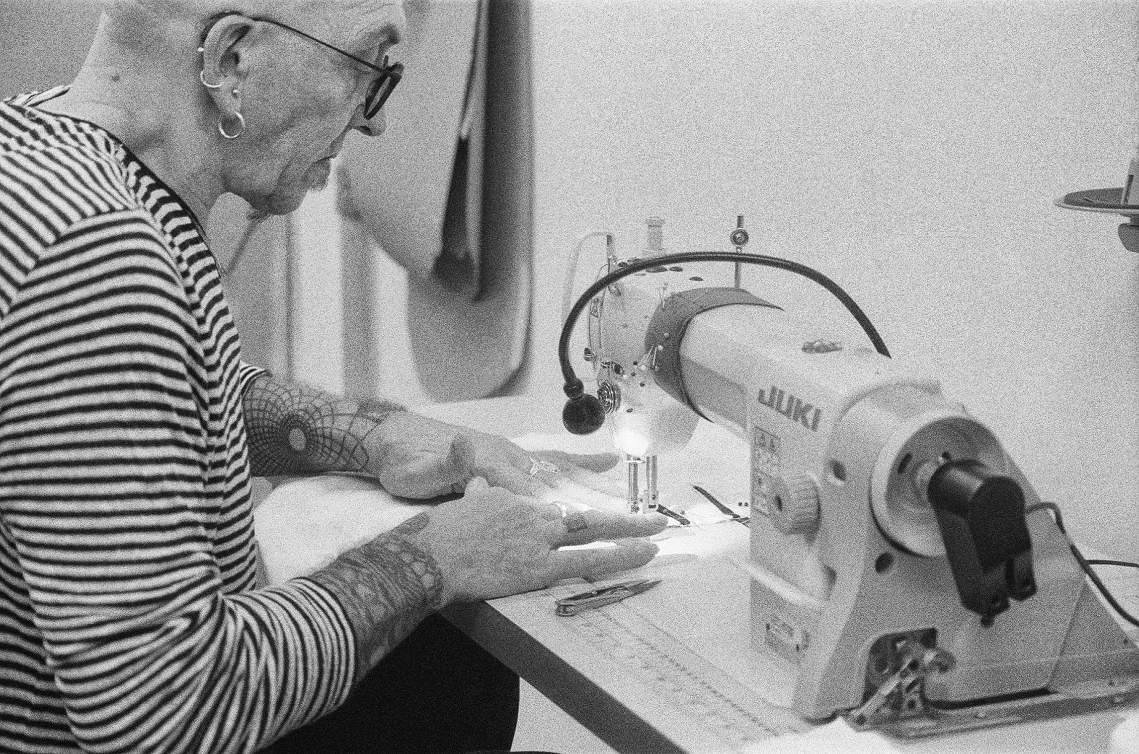 Photograph of Andi Walker working at sewing machine 
