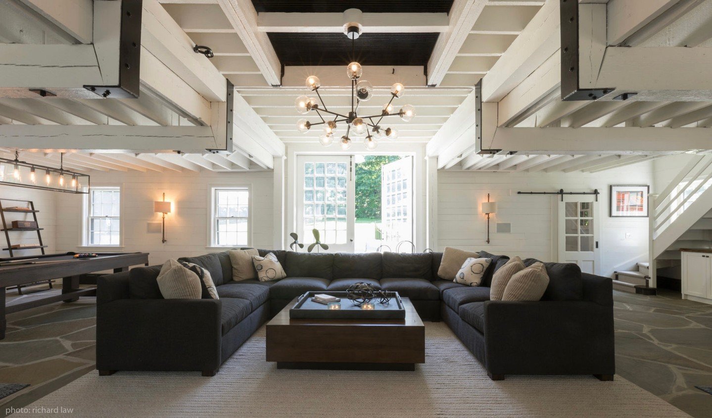 Swipe to see the ultimate barn transformation 🤍✨
From hay bales to happy hours &mdash; this cozy sectional anchors the space, with spots for dining, game nights, and laid-back lounging. And yes, we tucked a bar under the stairs because every good ga