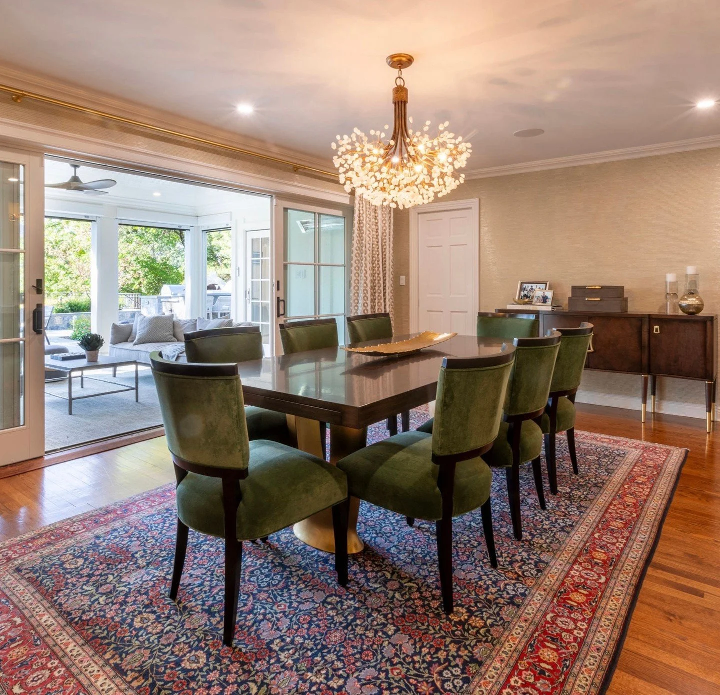 Seamless indoor-outdoor entertaining ✨ We gave this dining room a fresh look by pairing our client&rsquo;s cherished oriental rug with rich dark wood furniture and lush green velvet chairs to pull the colors together. A custom built-in keeps china an