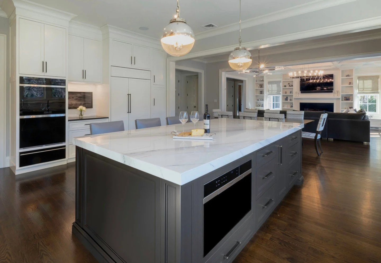 Bold and timeless, this kitchen makes a statement 🖤 The charcoal-painted island is mirrored in the custom hood, adding dramatic contrast against the bright upper cabinets. Matte black and polished nickel accents bring depth and sophistication, while