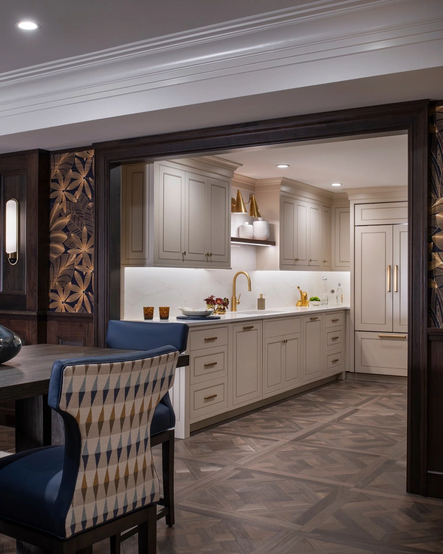 The lower-level kitchen designed for effortless entertaining &mdash; where function meets sophistication.
Soft neutral cabinetry pairs with brushed brass accents and a feature mini bar of marble, mosaic, and shimmer &mdash; creating a seamless flow b