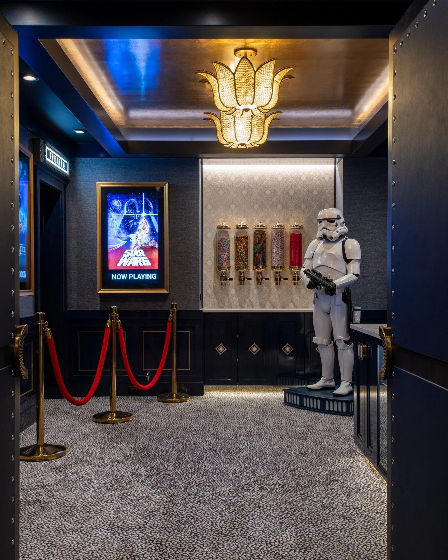 A nod to classic cinema with a playful twist &mdash; this lower-level concession stand brings vintage charm to a modern home theater.
From the custom millwork and golden lighting to the life-size Stormtrooper guarding the sweets, every detail was des