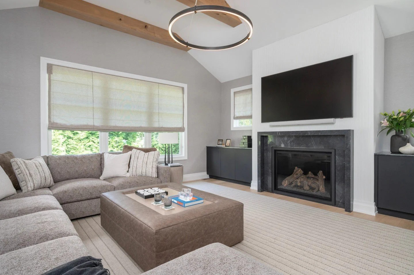 A family room made for everyday living &mdash; relaxed, refined, and effortlessly cohesive.
Soft neutrals, warm textures, and rich layers of taupe and charcoal create a space that feels both grounded and inviting. The custom fireplace surround, moder