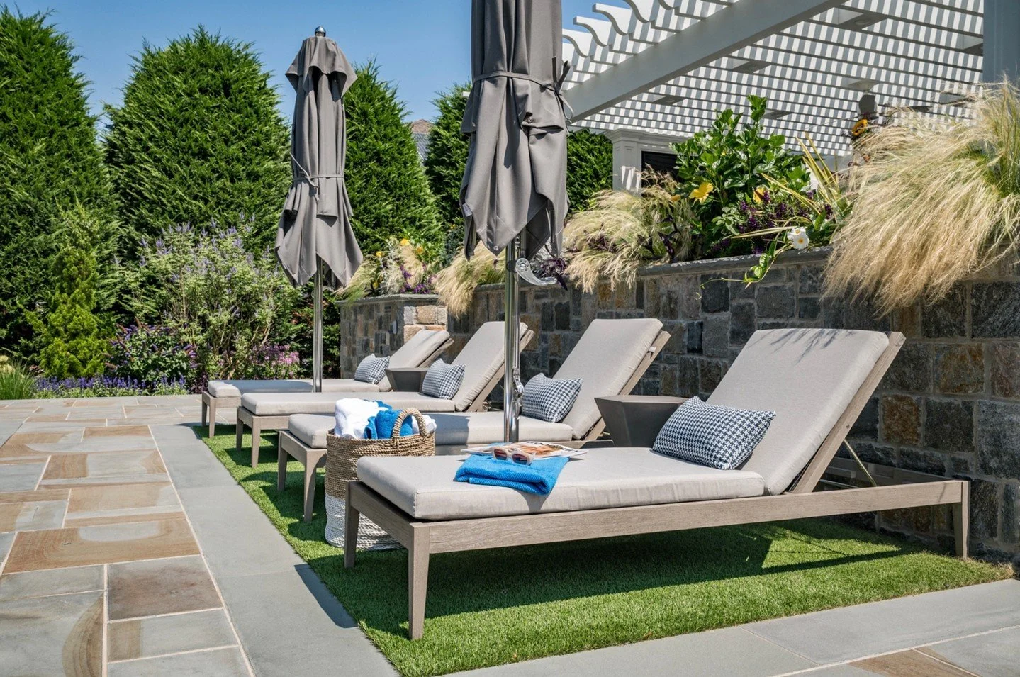 Poolside, perfectly placed ✨
Tailored chaises line the water&rsquo;s edge, layered against natural stone and lush landscaping for a look that feels both refined and relaxed. Soft neutral cushions, structured umbrellas, and thoughtful styling create a