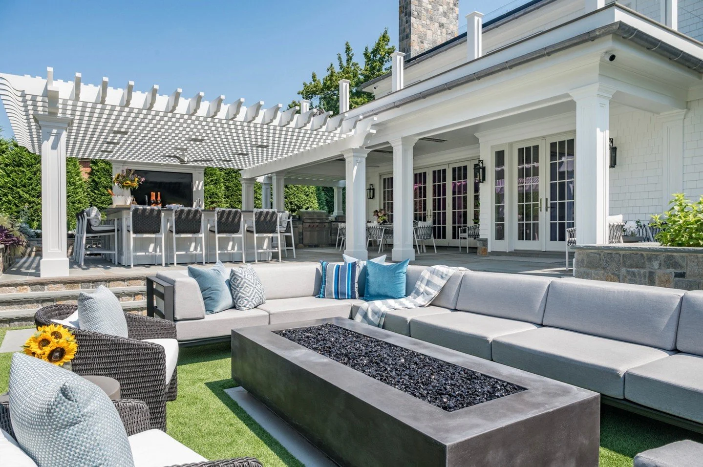 Just steps from the house, this lounge was created for gathering after sunset. ✨
The generous sectional wraps around a sleek fire feature, setting the stage for relaxed evenings and easy conversation. Soft grays paired with layered blues keep the pal
