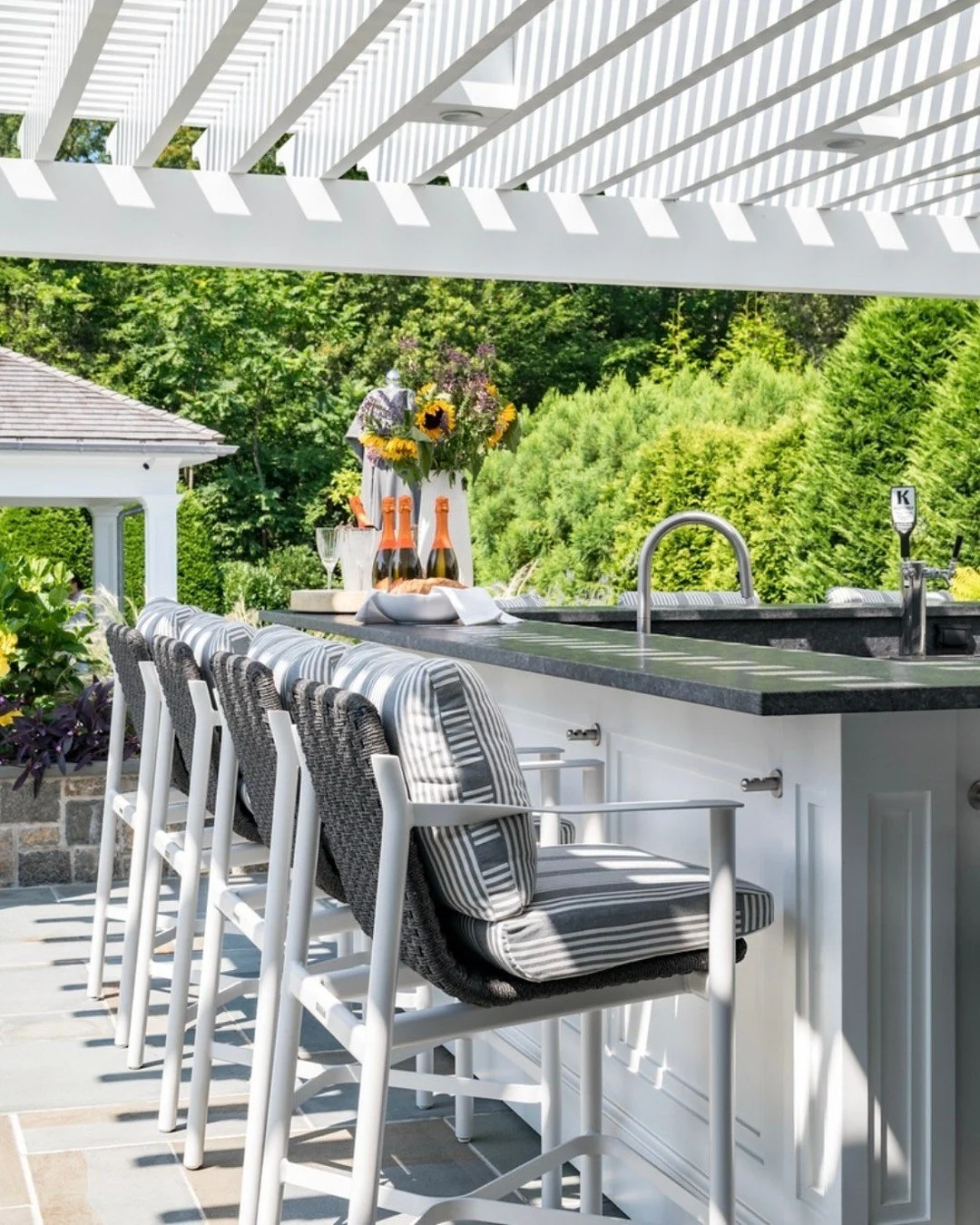 A closer look at the bar ✨
Crisp white millwork, striped cushions, and woven textures layered beneath the pergola&rsquo;s shadow play. Polished, relaxed, and ready for cocktails by the pool. 🍾🌿
📸: @timhillphoto