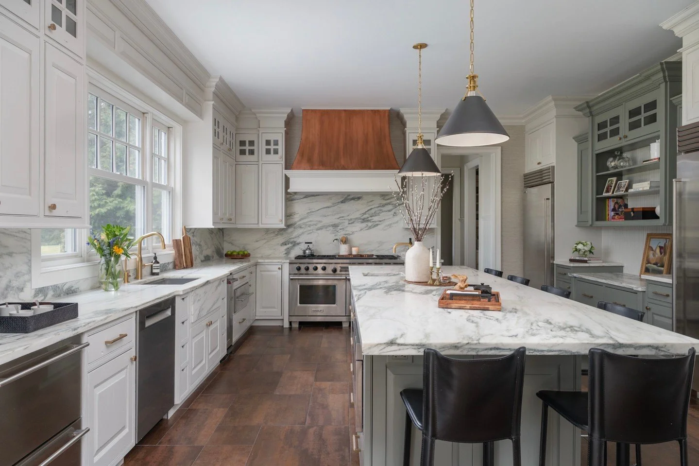 A fresh take on a classic kitchen 🤍
The perimeter cabinetry is painted in Sherwin Williams City Loft, creating a soft, airy backdrop, while the island in Sherwin Williams Willow Leaf introduces a refined, earthy green. Layered with honed marble coun