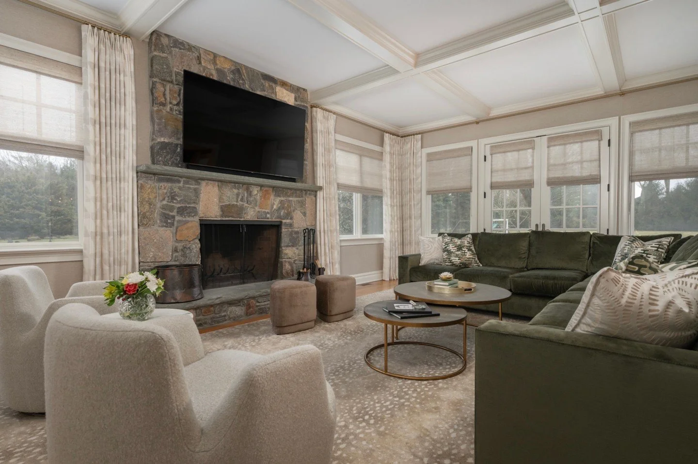 A space designed for gathering 🤍
This family room balances comfort and sophistication&mdash;anchored by the natural stone fireplace and layered with soft neutrals and rich green tones. Plush seating invites you to settle in, while warm textures, tai