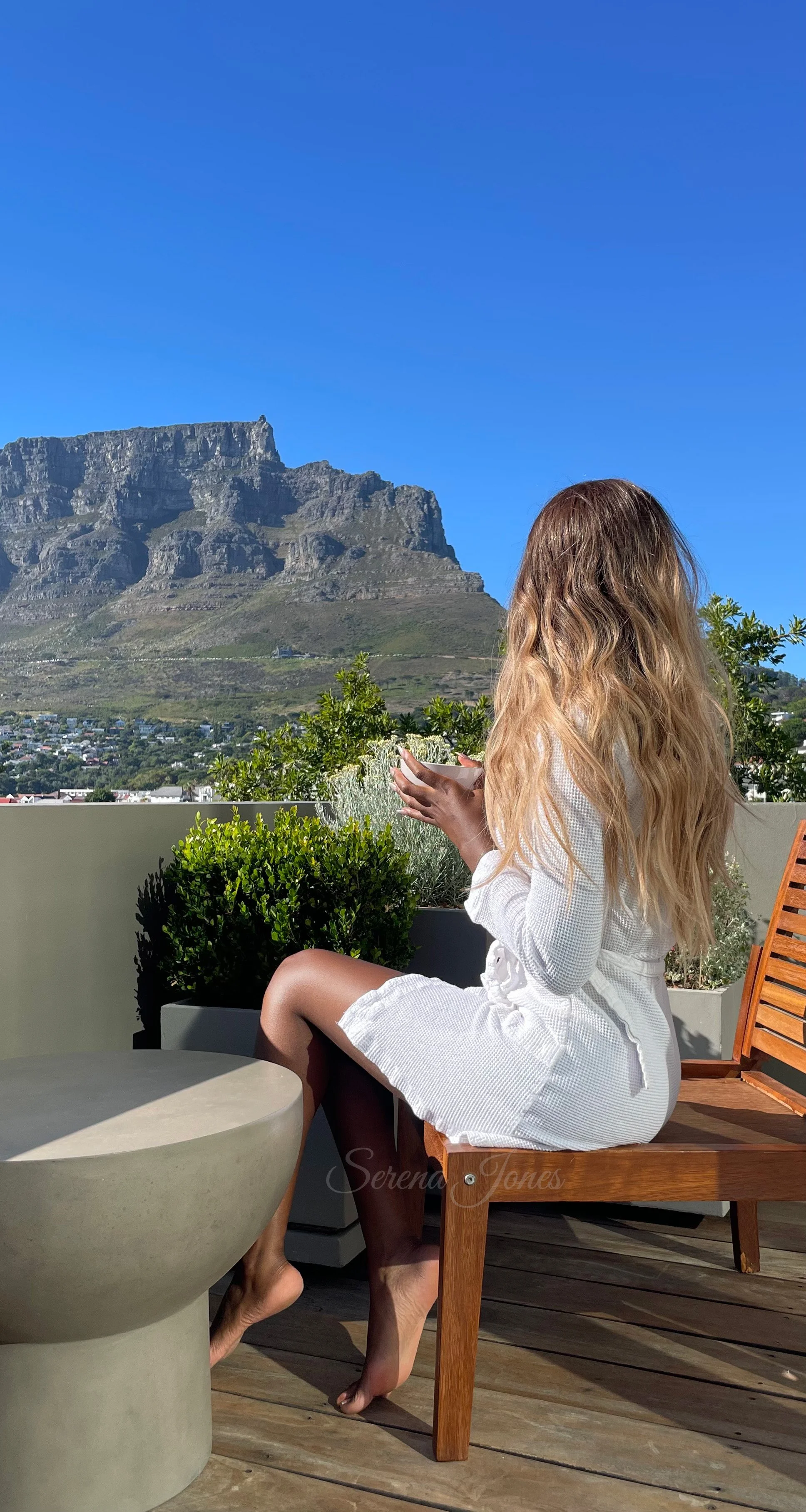 Serena Jones luxury escort Cape Town sitting on a chair looking at table mountain