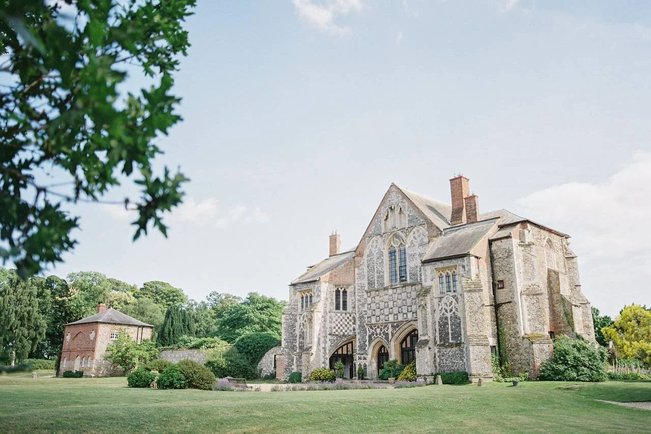 A historic stone church with Gothic architecture, arched windows, and a landscaped lawn in front.