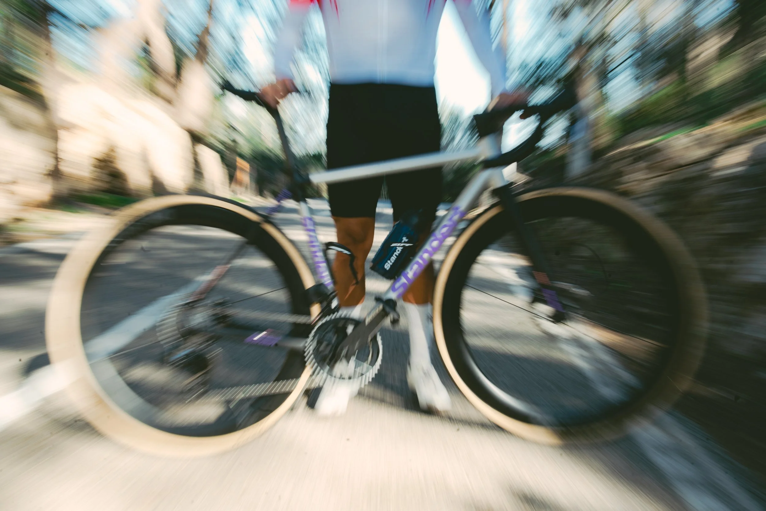 Person riding a bike on the road with motion blur effect.
