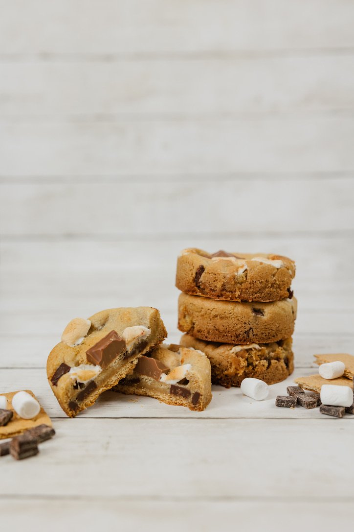 S'Mores - Buttery, brown sugar cookie dough filled with chocolate chunks, and marshmallows, baked over a graham cracker, and topped with more marshmallows