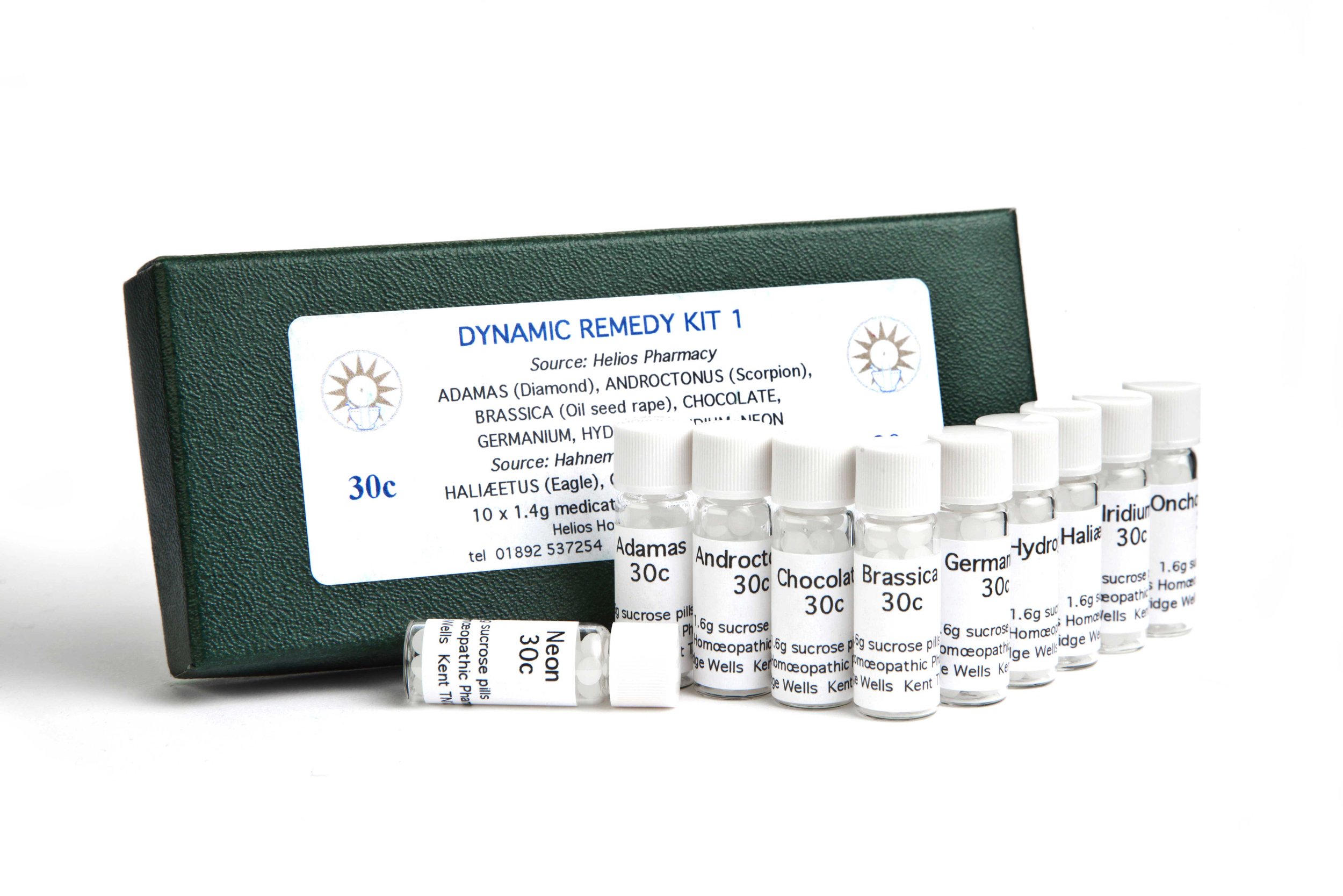 Set of homeopathic remedy vials labeled with different names, placed in front of a green box with a white label containing information about the remedy kit.