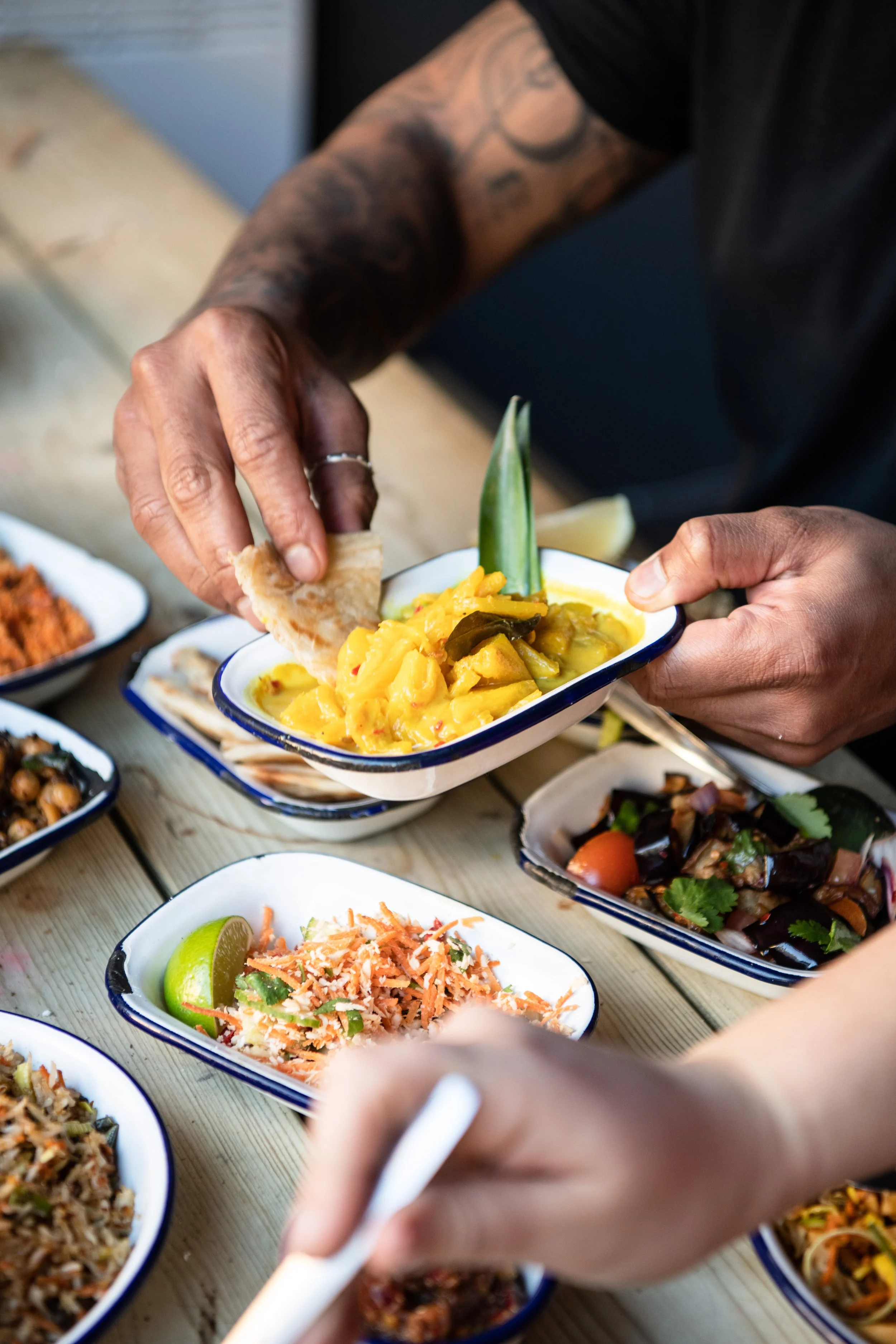hand dipping into authentic sri lankan restaurant dishes