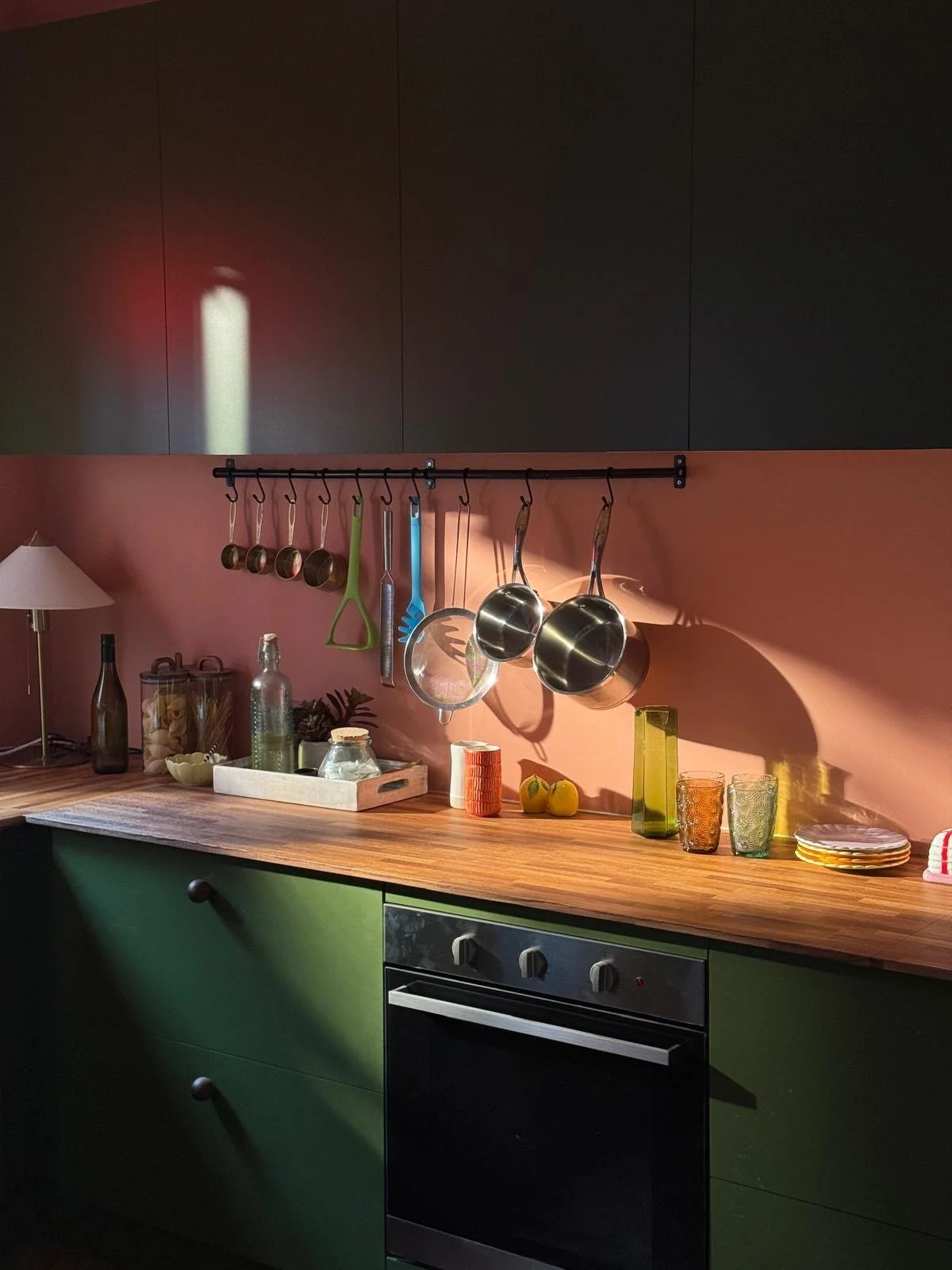 bespoke set kitchen painted in strong colours with kitchen accessories on worktop