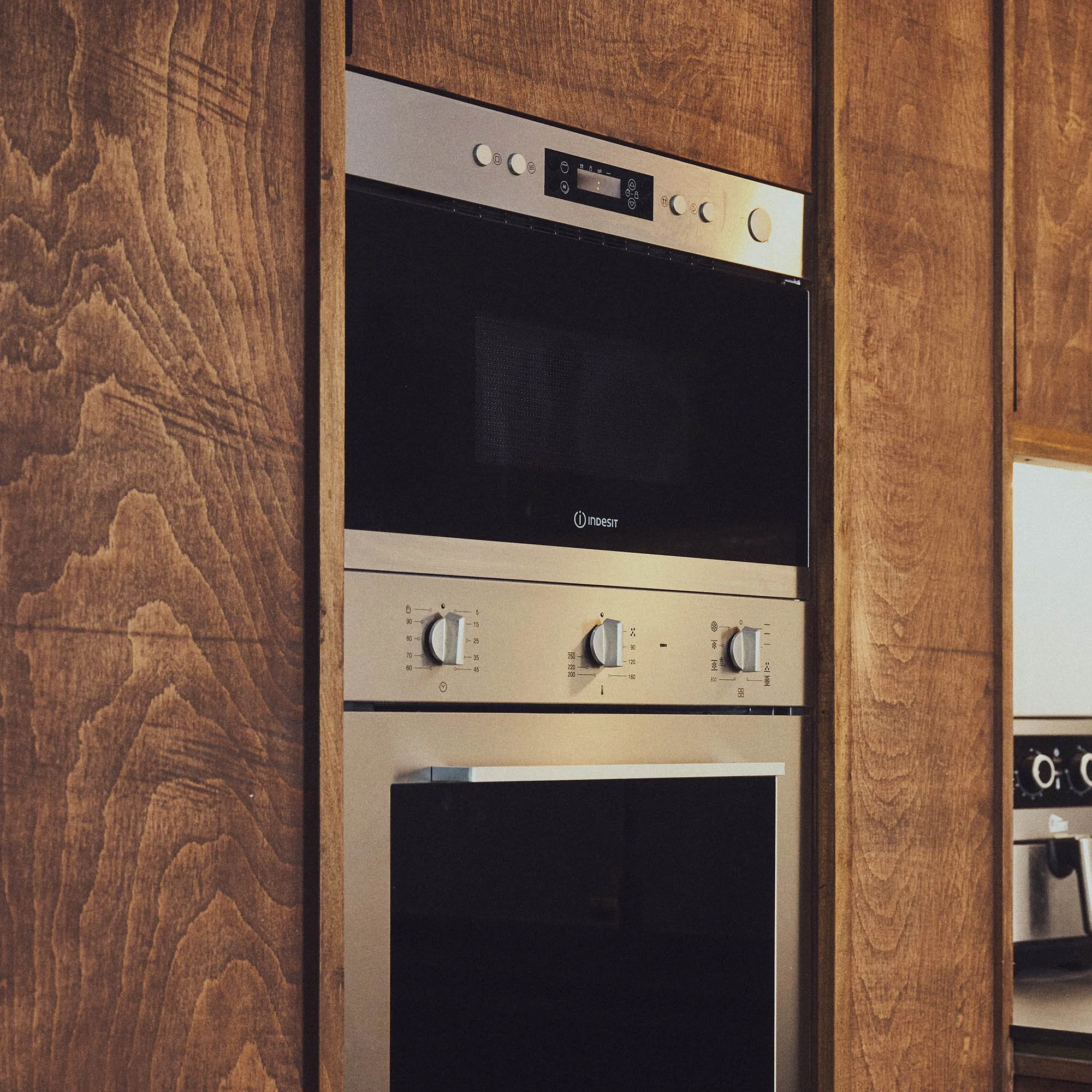 Stainless steel double inset oven in dark brown wooden kitchen