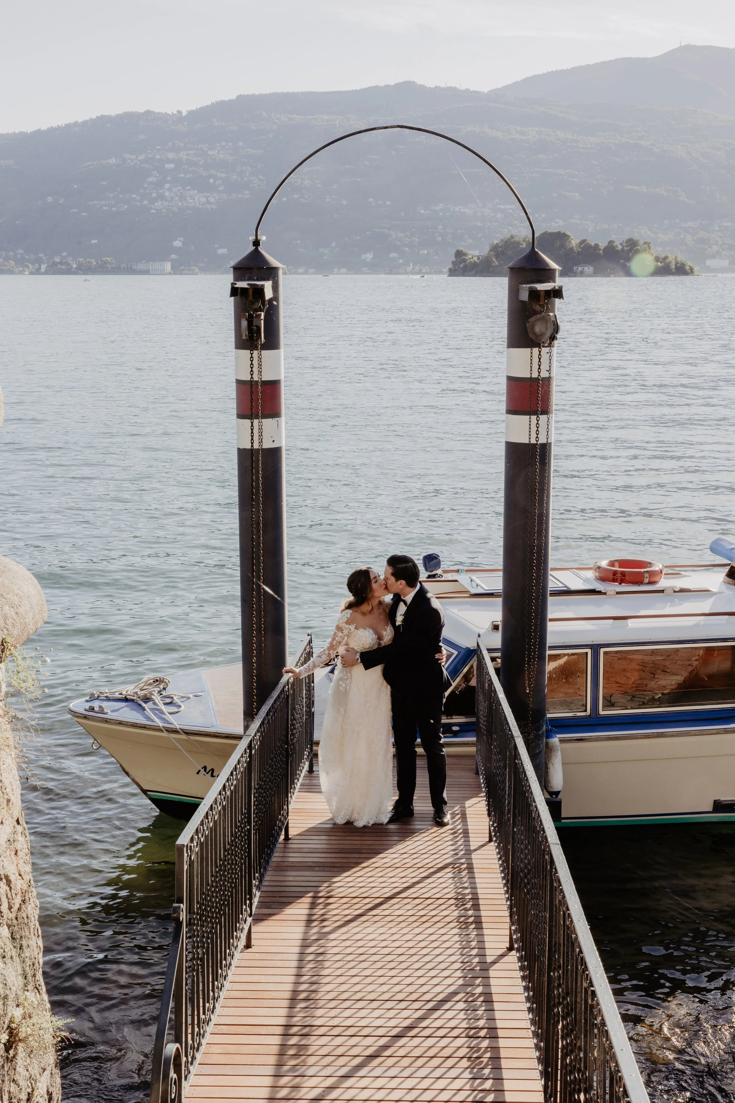 A romantic couple portrait on a Lake Como pier at their wedding planned by native Italian planner Lalla Crippa