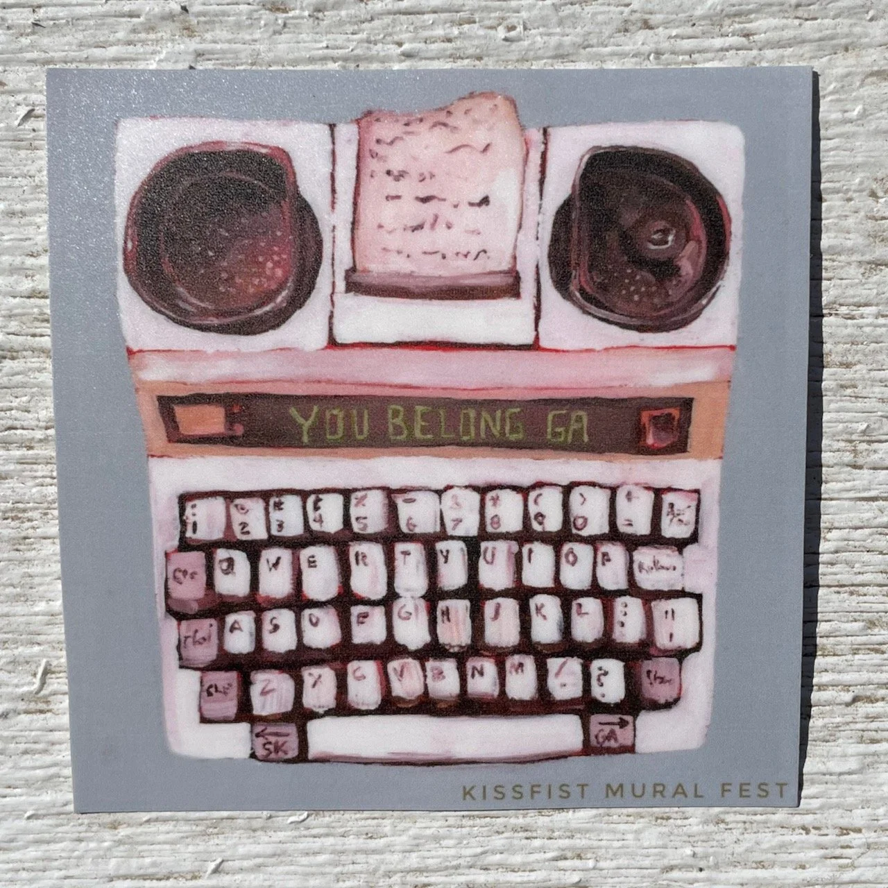 the you belong tty sticker placed on a weathered white wooden banister