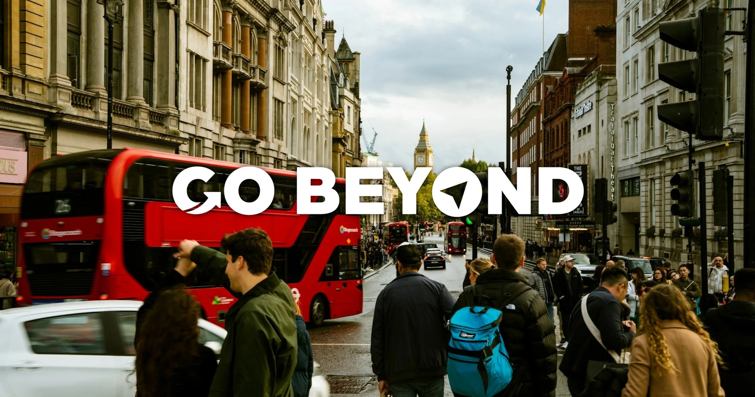 A busy London street scene filled with pedestrians and a iconic red double-decker bus. The Elizabeth Tower (Big Ben) is visible in the distance under a cloudy sky, with the white text "GO BEYOND" overlaid across the center of the frame.