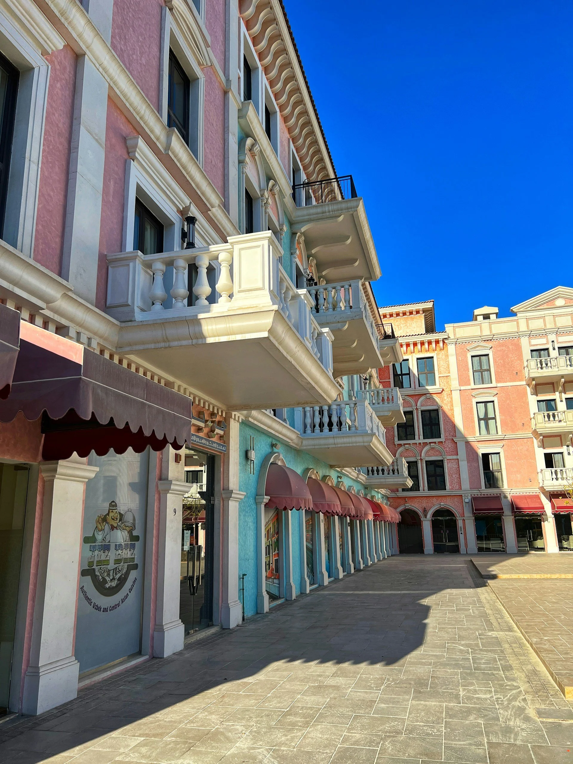 Colorful Venetian-style apartment buildings and shopfronts in Qanat Quartier at The Pearl-Qatar, Doha.