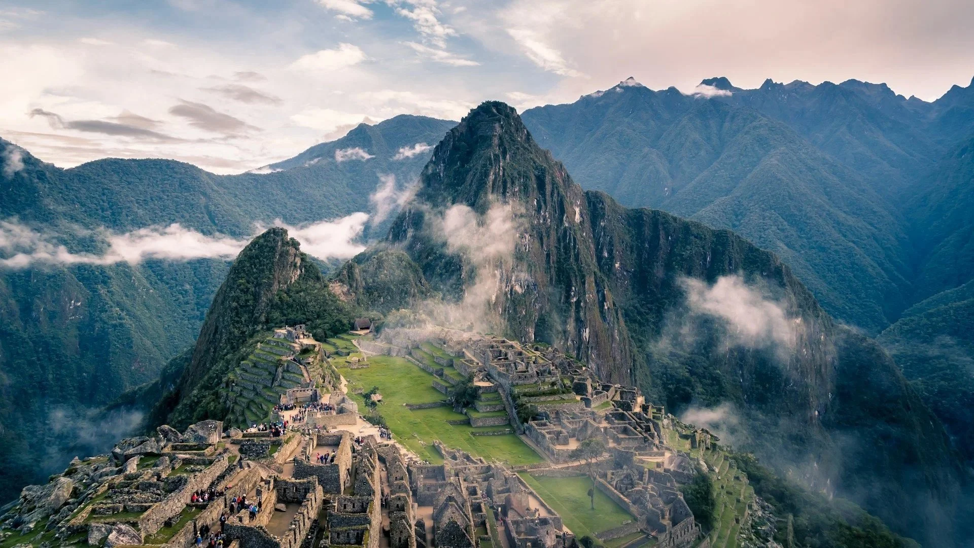 The ancient Inca citadel of Machu Picchu nestled among lush, mist-covered Andean mountain peaks.
