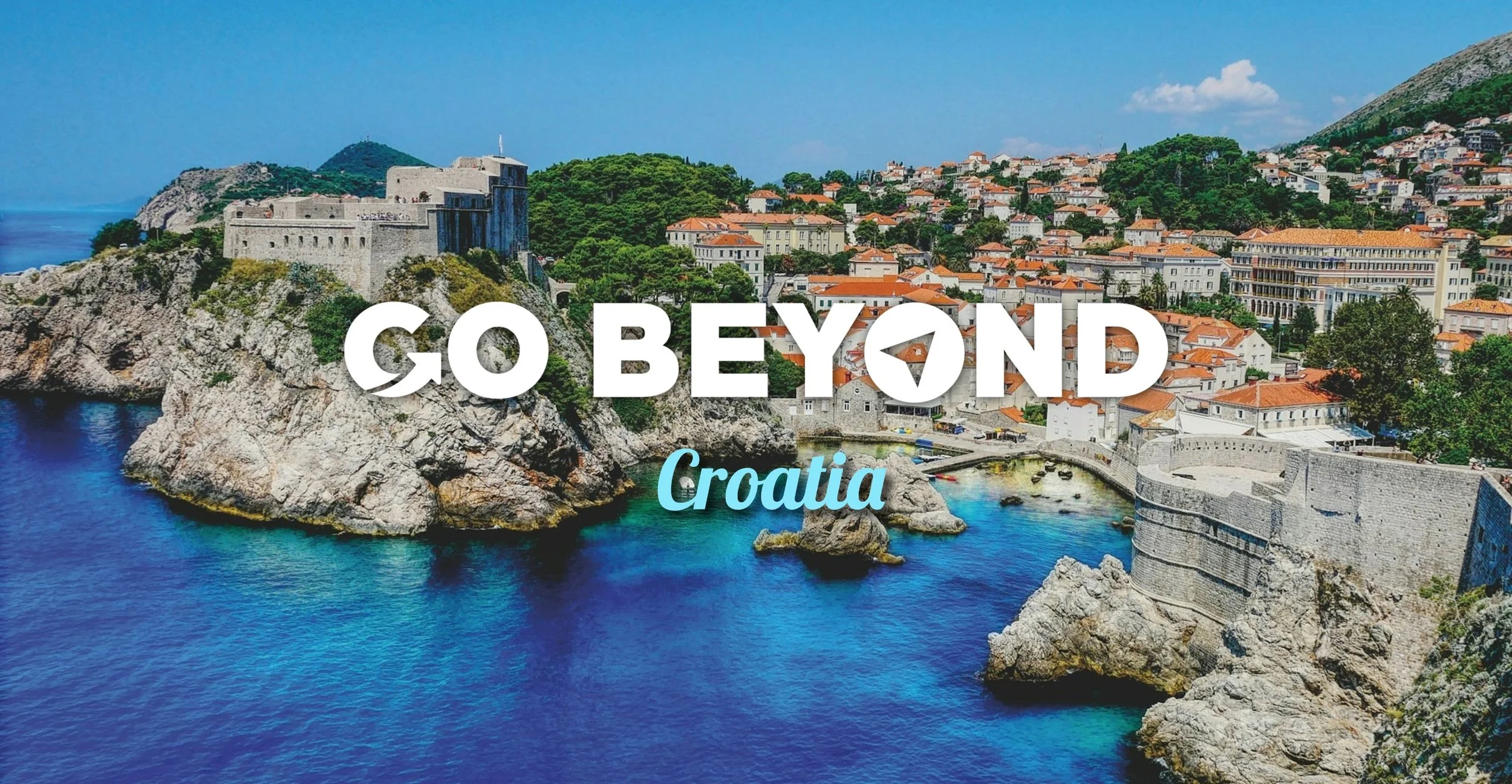 A scenic coastal view of Dubrovnik's rocky shores and turquoise water with the text "GO BEYOND Croatia."